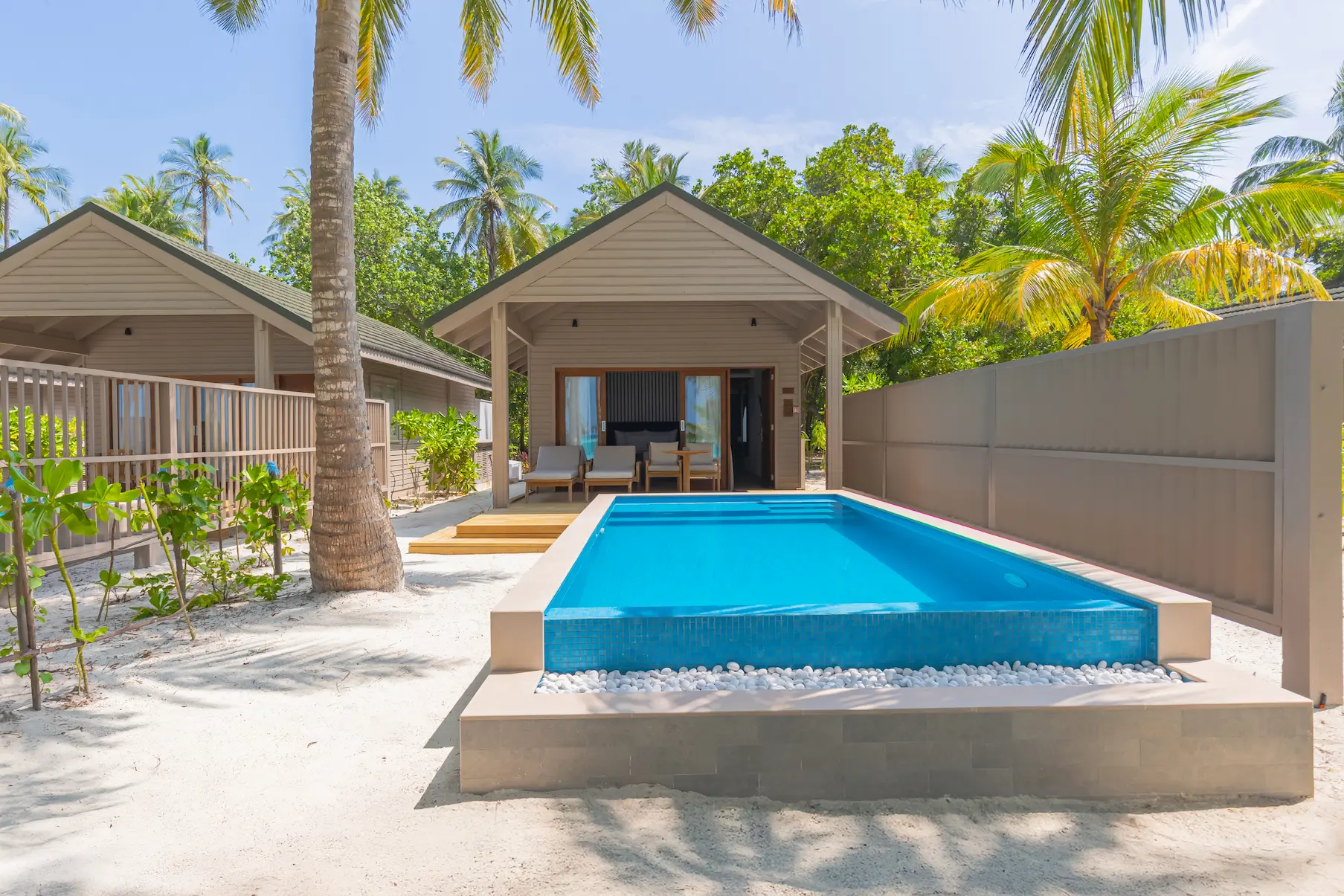 meeru maldives beach pool villa exterior surrounded by tropical greenery with private pool and direct beach access in a serene island setting