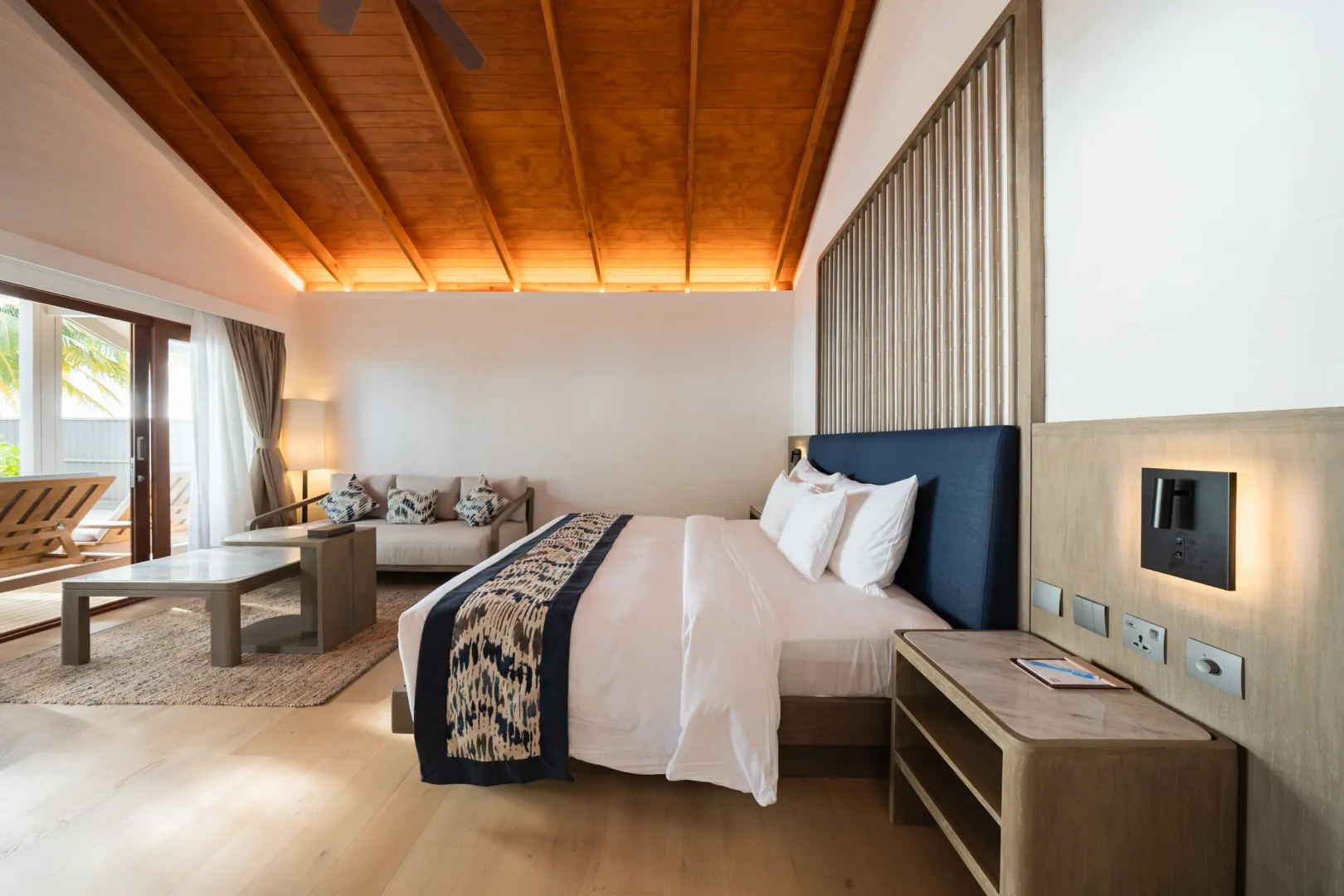 meeru maldives beach pool villa king bed featuring elegant interiors, natural textures and a tranquil tropical atmosphere with direct access to private outdoor space