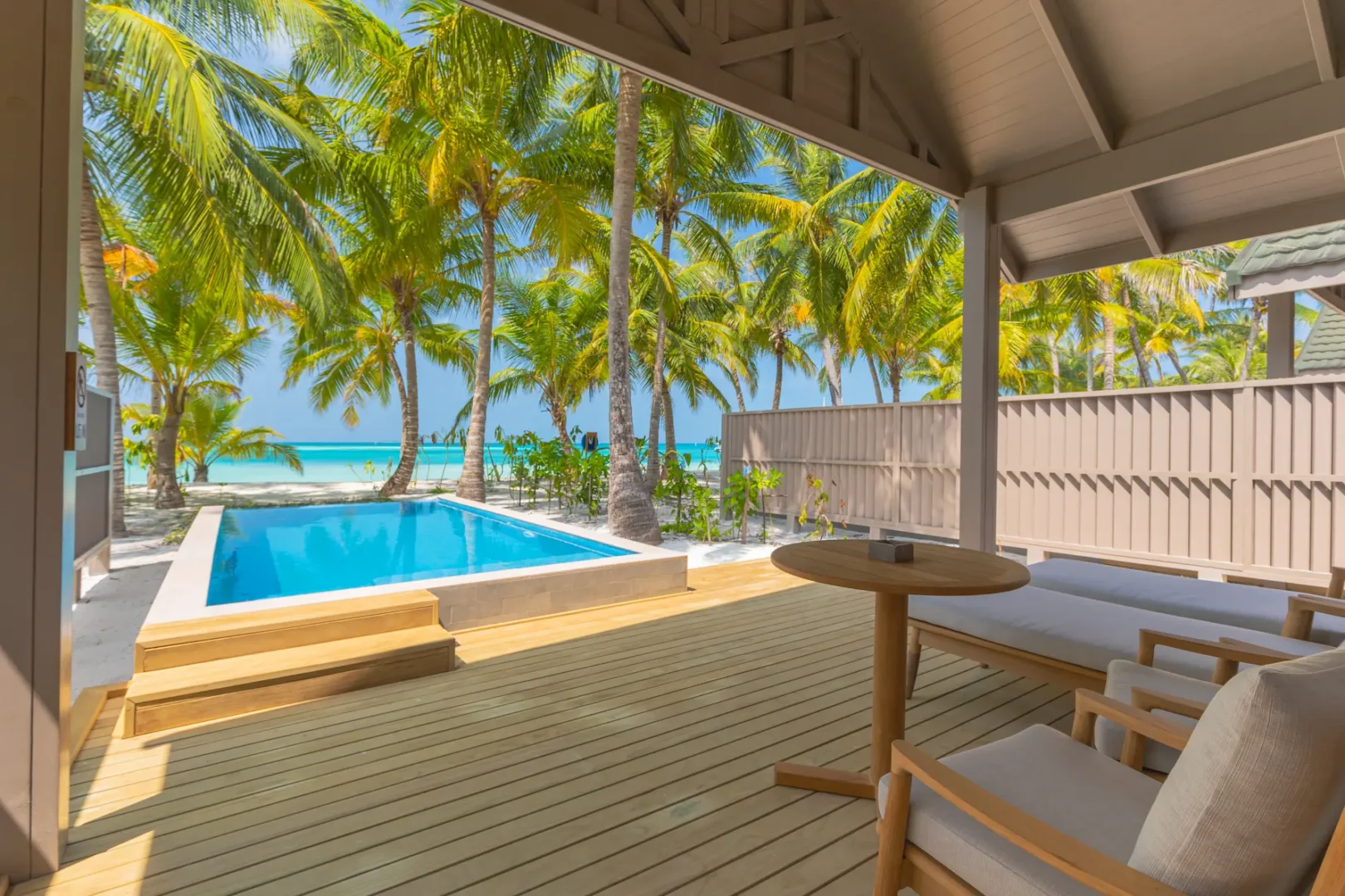 meeru maldives beach pool villa exterior surrounded by tropical greenery with private pool and direct beach access in a serene island setting