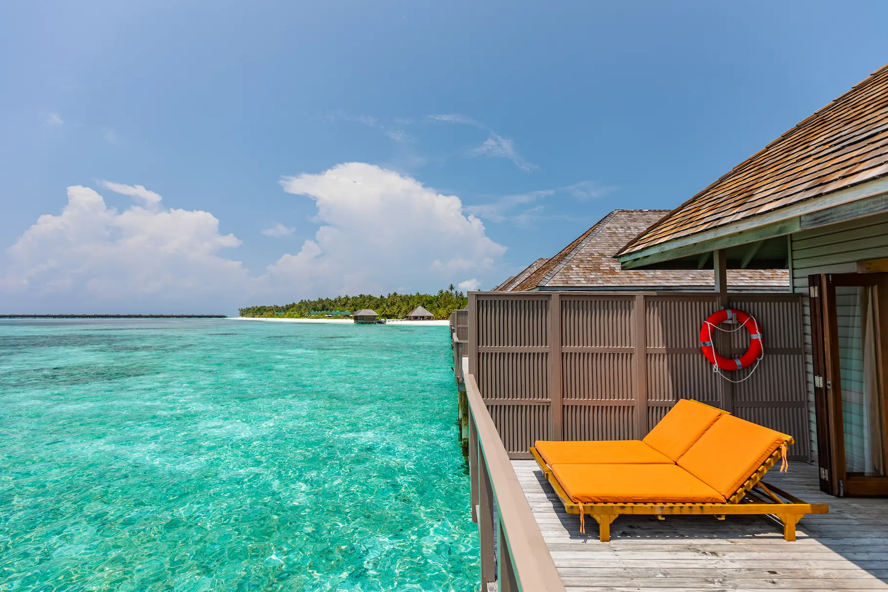 meeru maldives ocean villa terrace with private outdoor space, sun loungers and uninterrupted views across the turquoise lagoon in a serene island setting