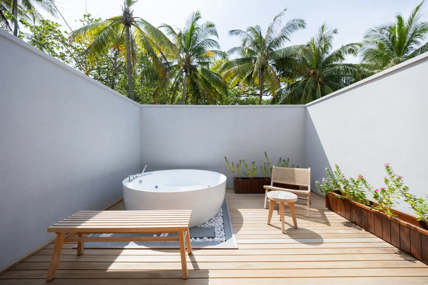 meeru maldives two bedroom beach pool villa bathroom featuring spacious open air design, elegant finishes and a tranquil tropical setting surrounded by lush greenery