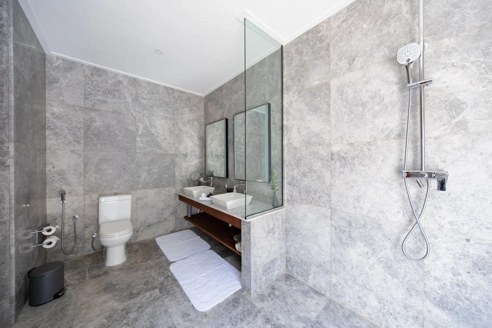 meeru maldives two bedroom beach pool villa bathroom featuring spacious open air design, elegant finishes and a tranquil tropical setting surrounded by lush greenery
