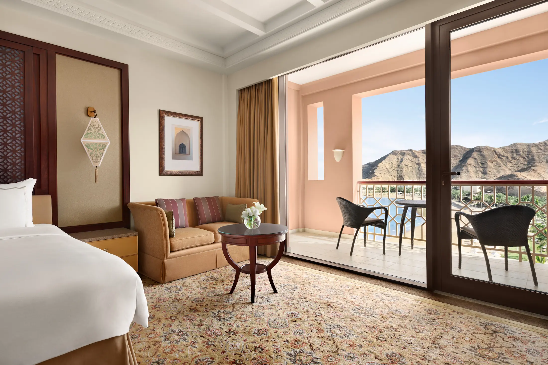 oman al husn hotel muscat deluxe room with sea view bedroom featuring elegant coastal interiors and refined design