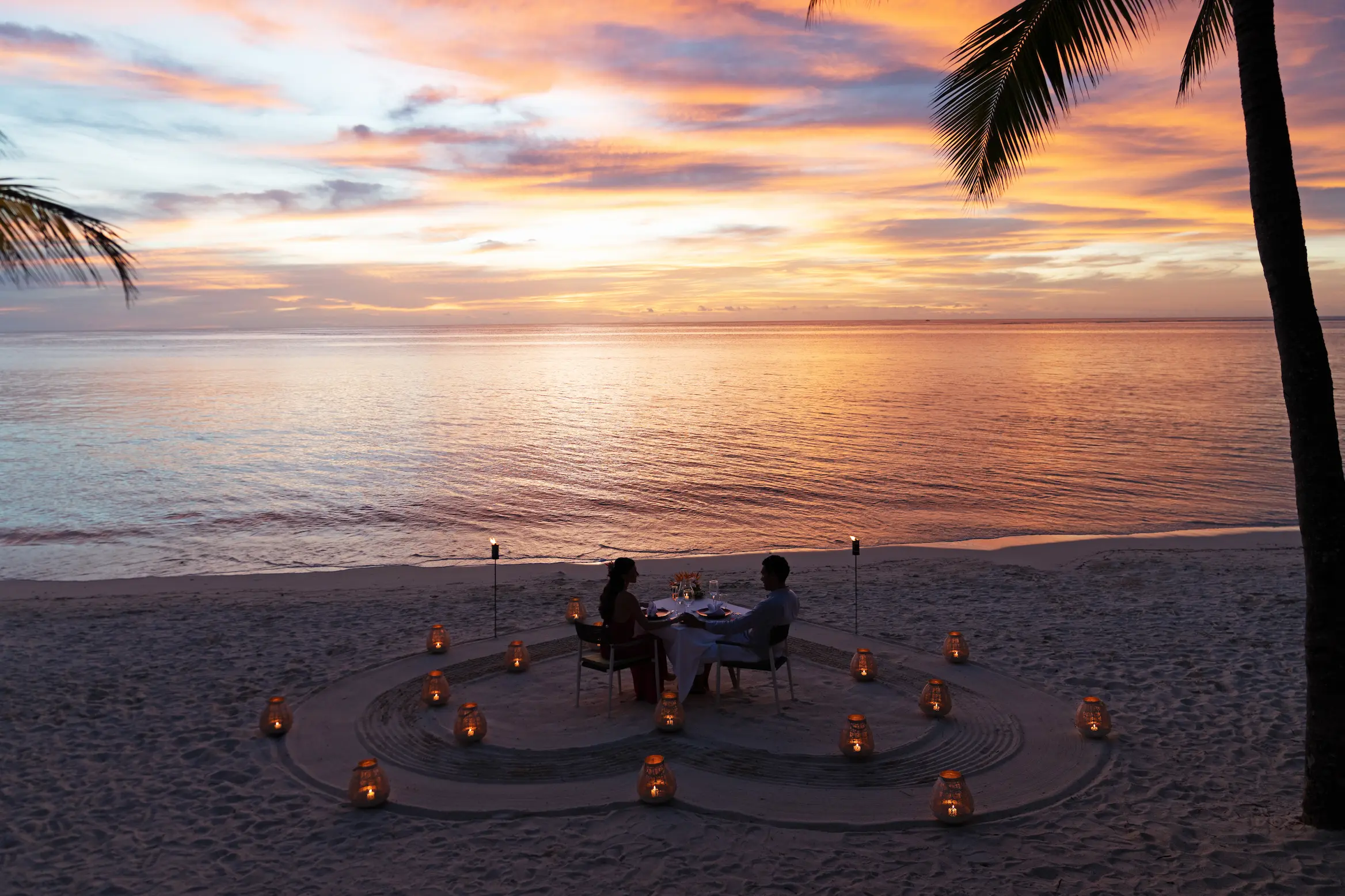 trou aux biches beachcomber golf resort spa mauritius candle lit dinner with elegant tableside décor romantic evening ambiance and luxury beachfront dining experience