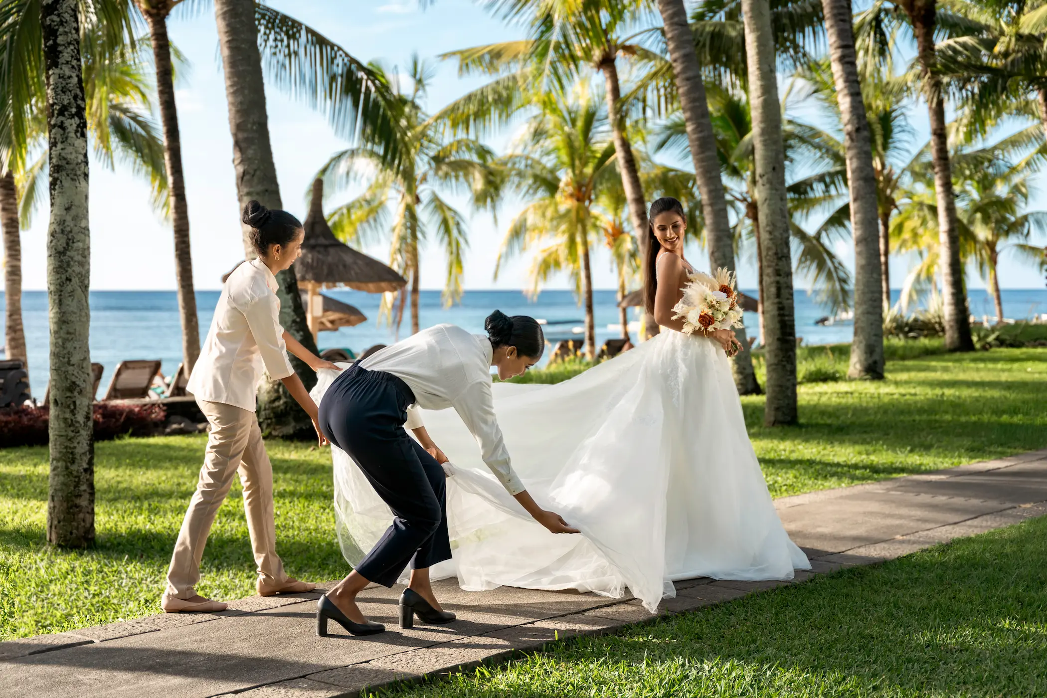 victoria beachcomber resort spa mauritius wedding bride walking through the resort in elegant bridal attire surrounded by tropical scenery and a romantic luxury wedding atmosphere