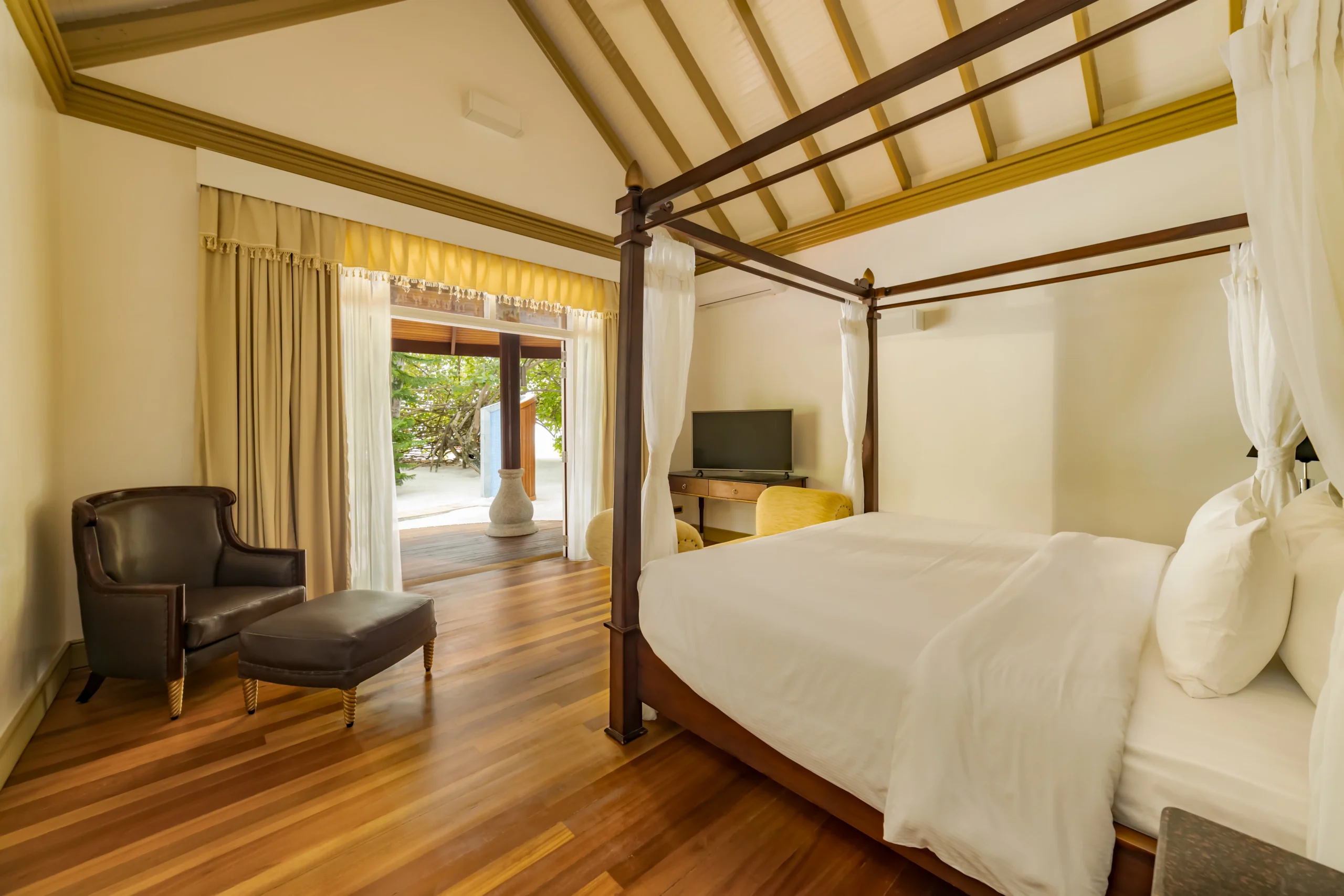 bedroom interior of a two bedroom beach suite at sun siyam olhuveli maldives featuring contemporary furnishings and spacious beachfront accommodation