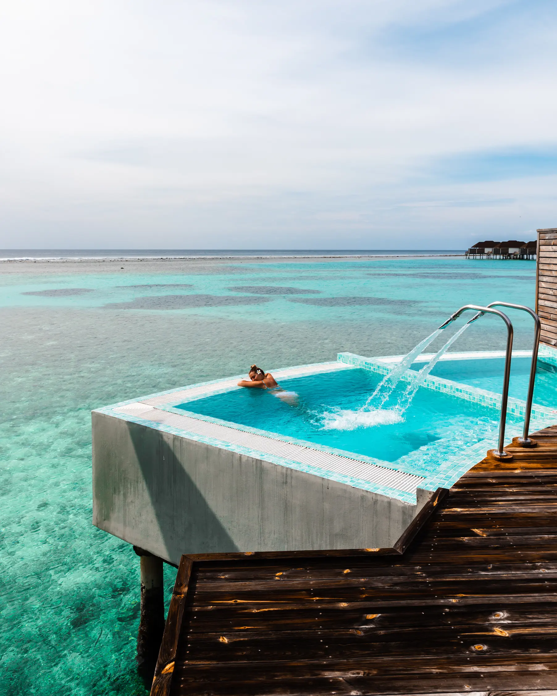 guests relaxing by a private pool at an overwater villa at sun siyam olhuveli maldives overlooking the lagoon