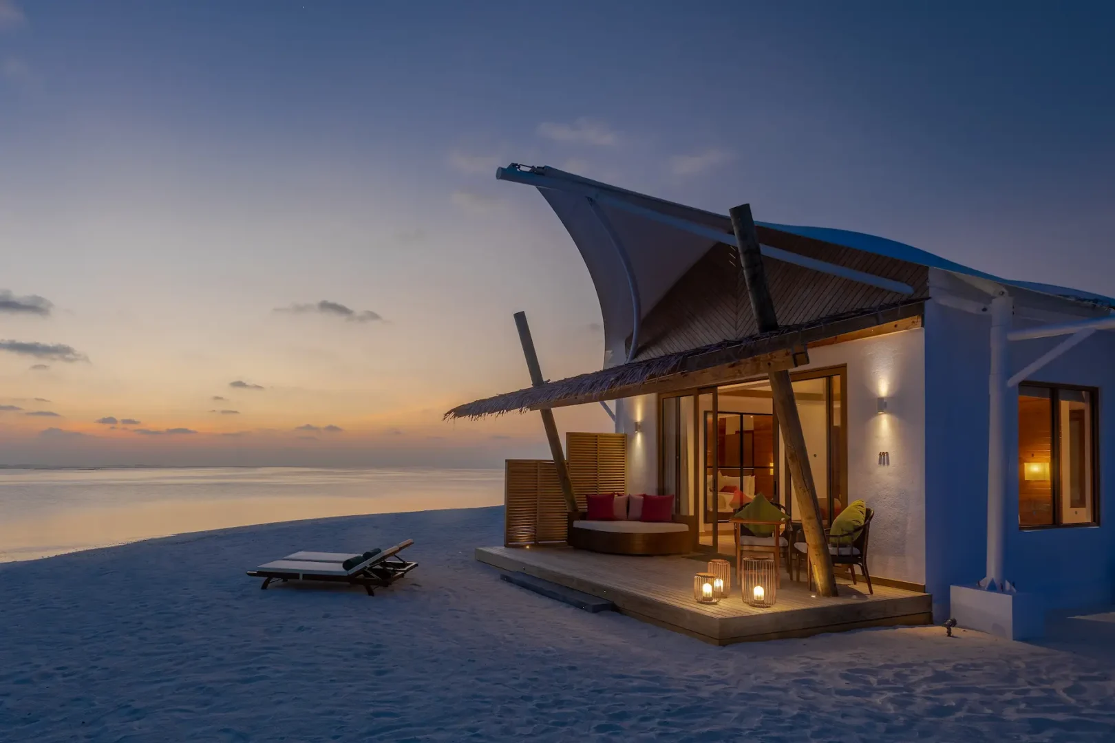 Platinum Beach Bungalow illuminated at night at Cinnamon Hakuraa Huraa Maldives, Maldives