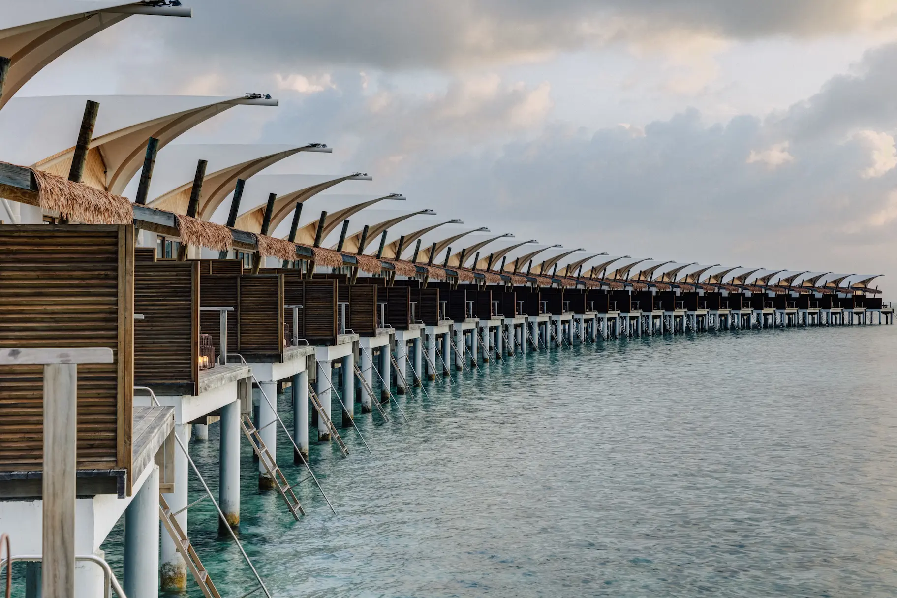 Row of Water Bungalows at Cinnamon Hakuraa Huraa Maldives, Maldives.