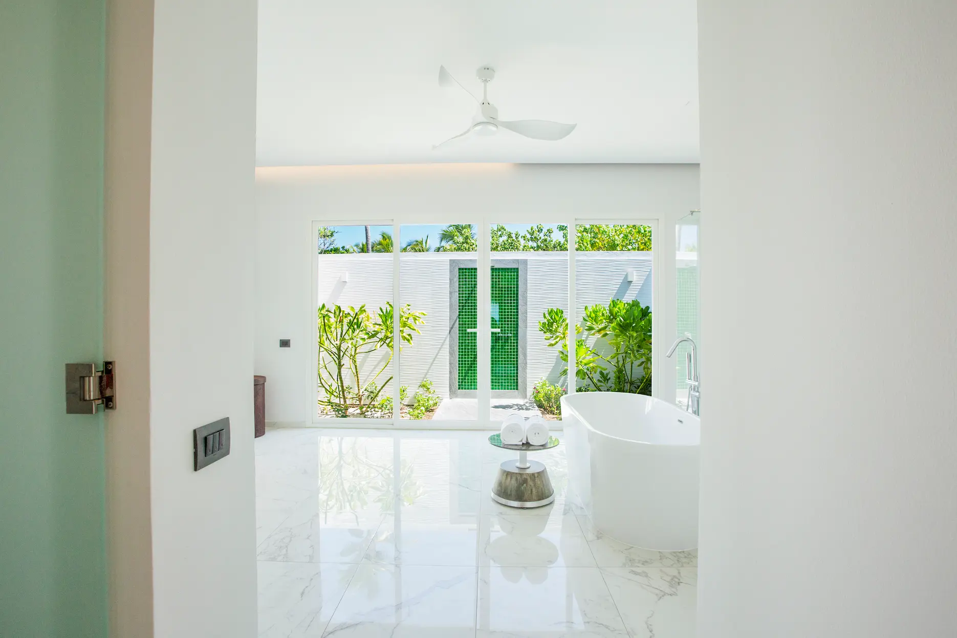 bathroom in a beach villa with pool at emerald maldives resort & spa in the maldives featuring a bathtub, walk-in shower and outdoor shower area