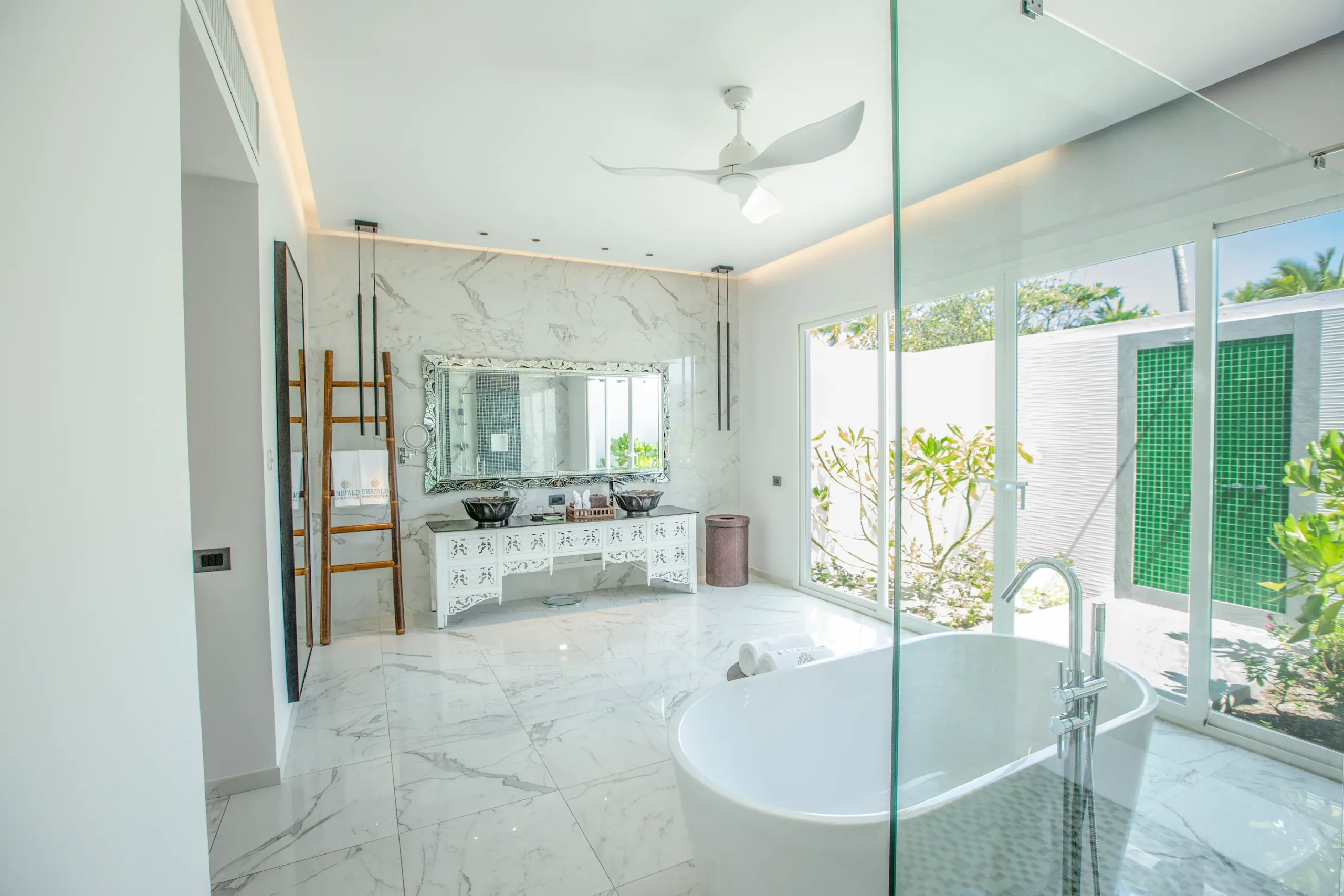 bathtub in a beach villa at emerald maldives resort & spa in the maldives overlooking the outdoor bathing area and private villa space