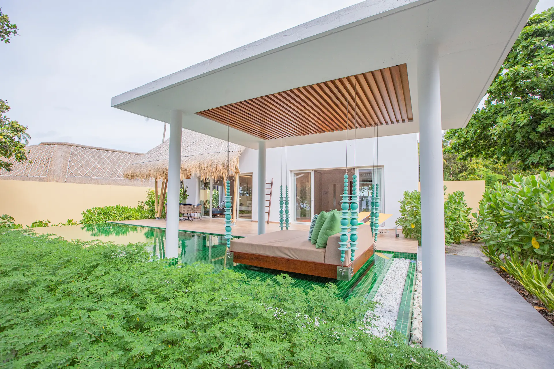 day bed on the outdoor terrace of a superior beach villa with pool at emerald maldives resort & spa in the maldives overlooking the private pool and beach surroundings