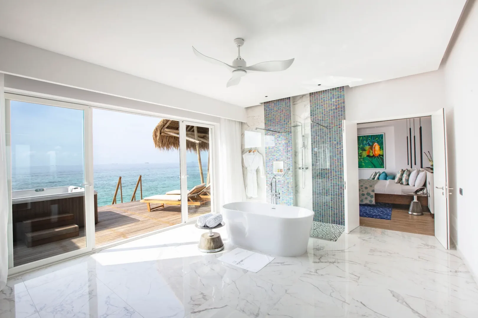 bathtub in a jacuzzi water villa at emerald maldives resort & spa in the maldives with views towards the private overwater sundeck and outdoor jacuzzi