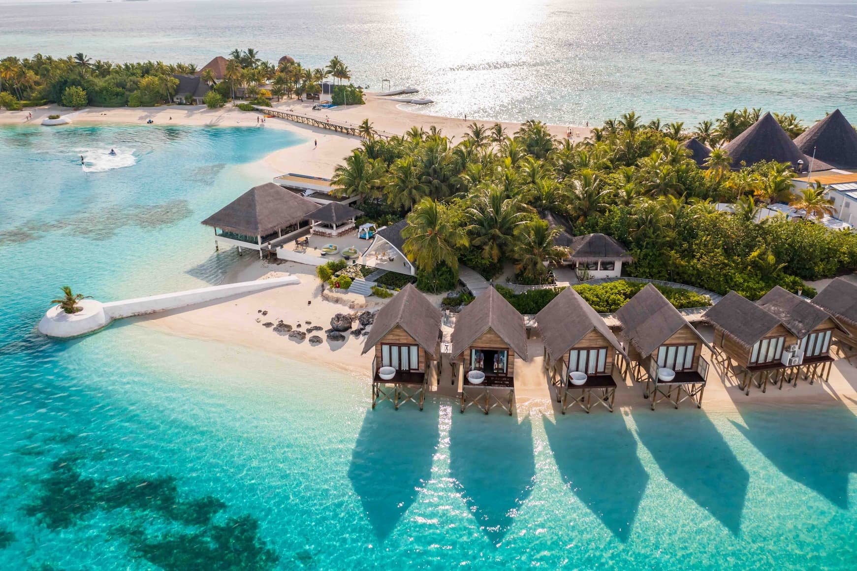 Aerial view of guests snorkelling in the lagoon at OZEN LIFE MAADHOO, showcasing the clear waters, surrounding reef areas and marine experiences available around the island.