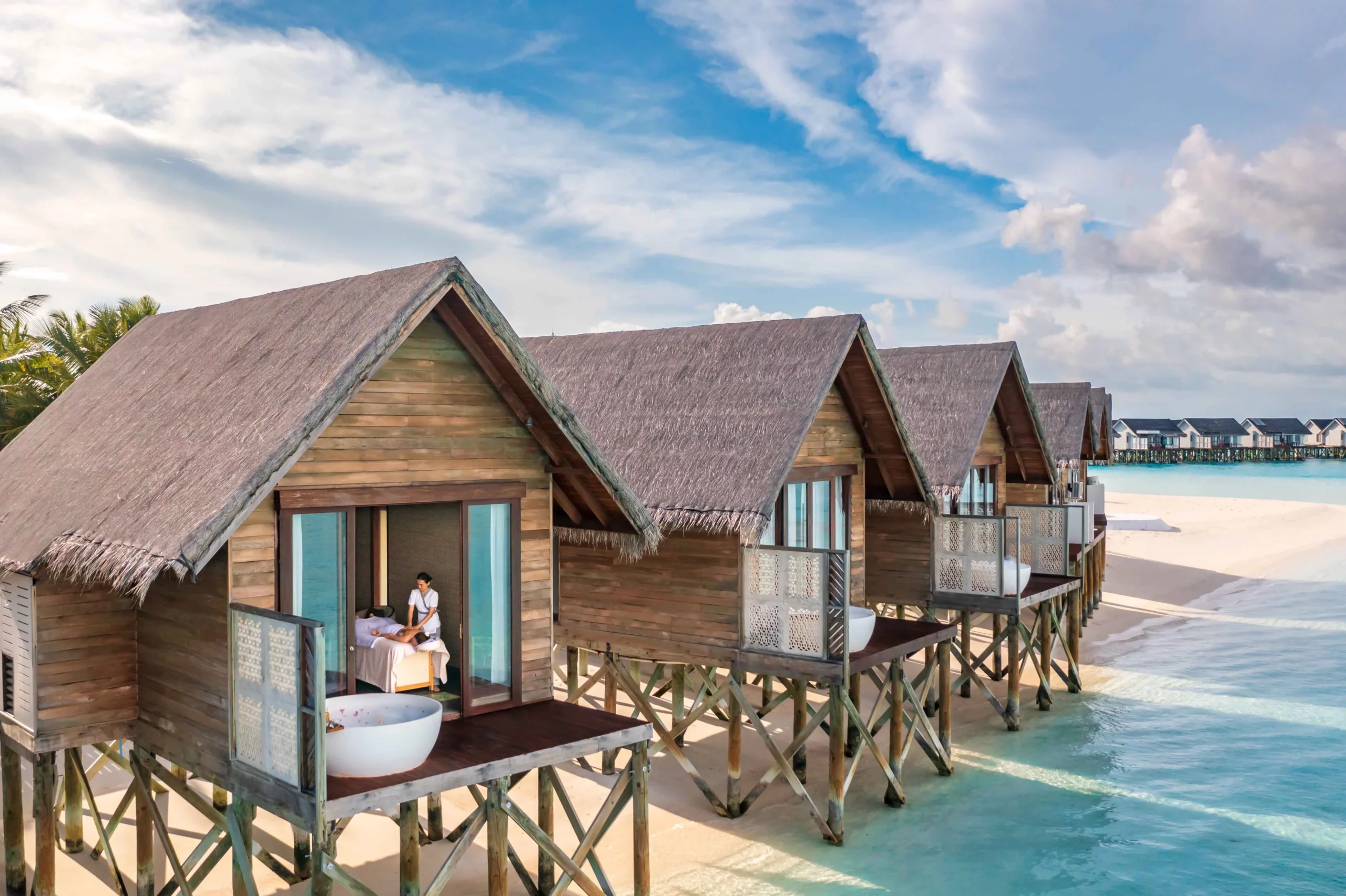 Treatment area at ELE | NA Spa at OZEN LIFE MAADHOO, featuring a tranquil overwater setting, wellness facilities and views across the lagoon.