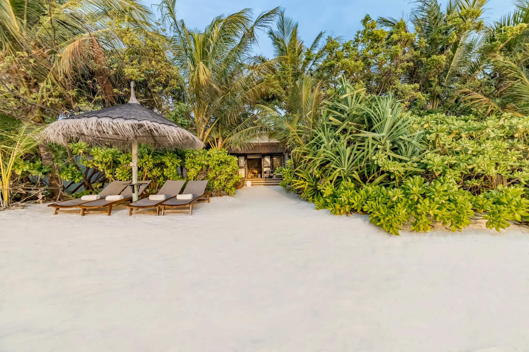 Beachfront area outside an Earth Pool Pavilion at OZEN LIFE MAADHOO, featuring direct access to the beach and spacious outdoor living areas close to the shoreline