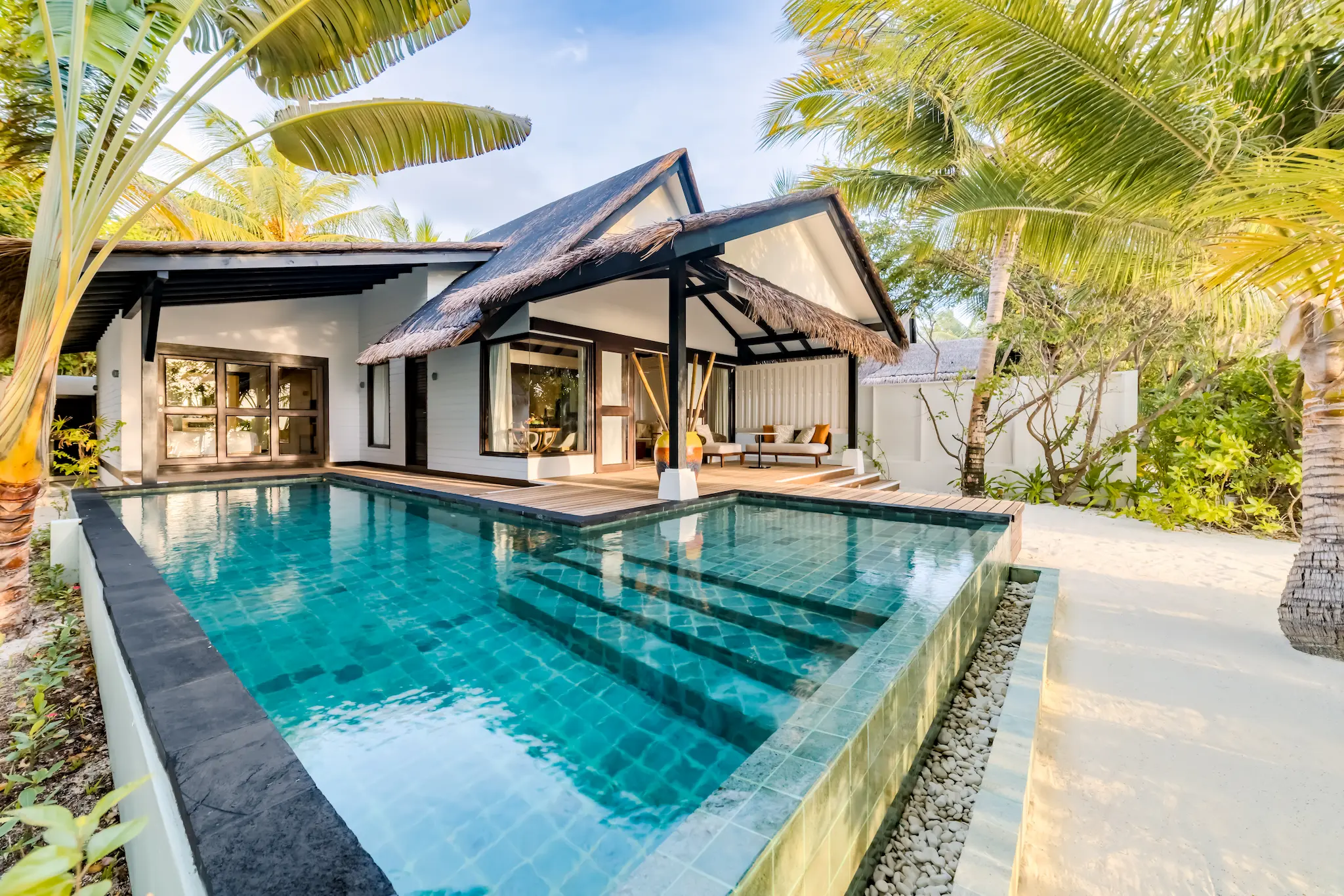 Exterior view of the private pool at an Earth Pool Pavilion at OZEN LIFE MAADHOO, showcasing the spacious outdoor living area and beachfront setting