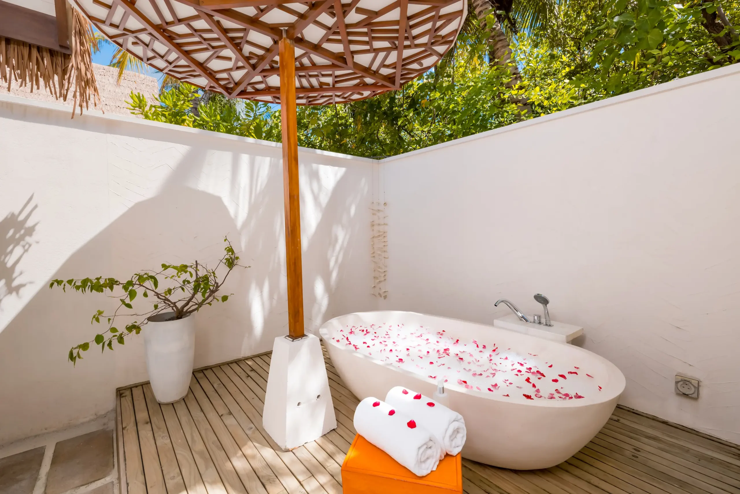 Freestanding bathtub in an Earth Villa at OZEN LIFE MAADHOO, featuring a spacious indoor-outdoor bathroom design close to the beach.