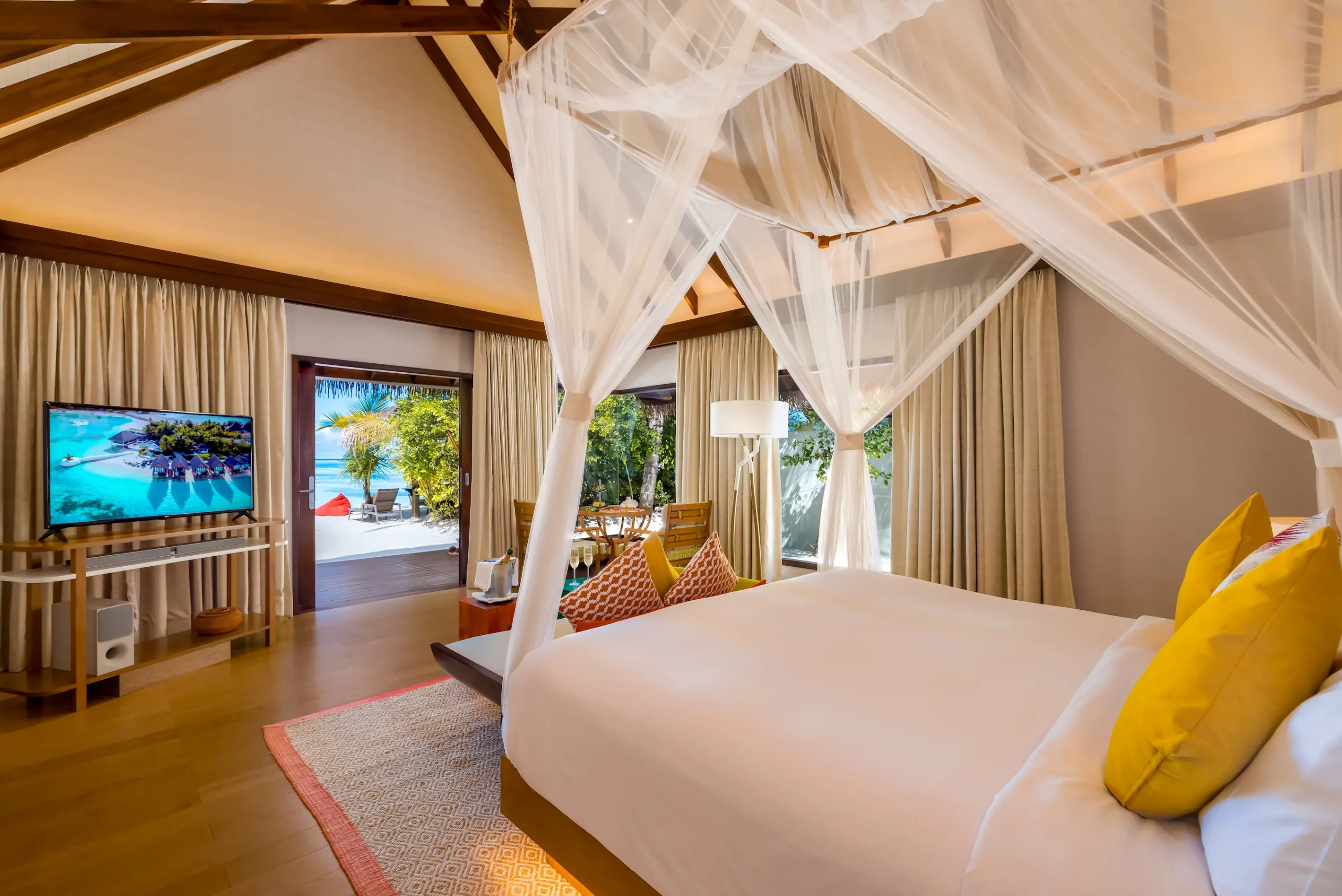 Spacious Earth Villa bedroom at OZEN LIFE MAADHOO featuring contemporary interiors, high sloping ceilings and direct access to an outdoor deck.