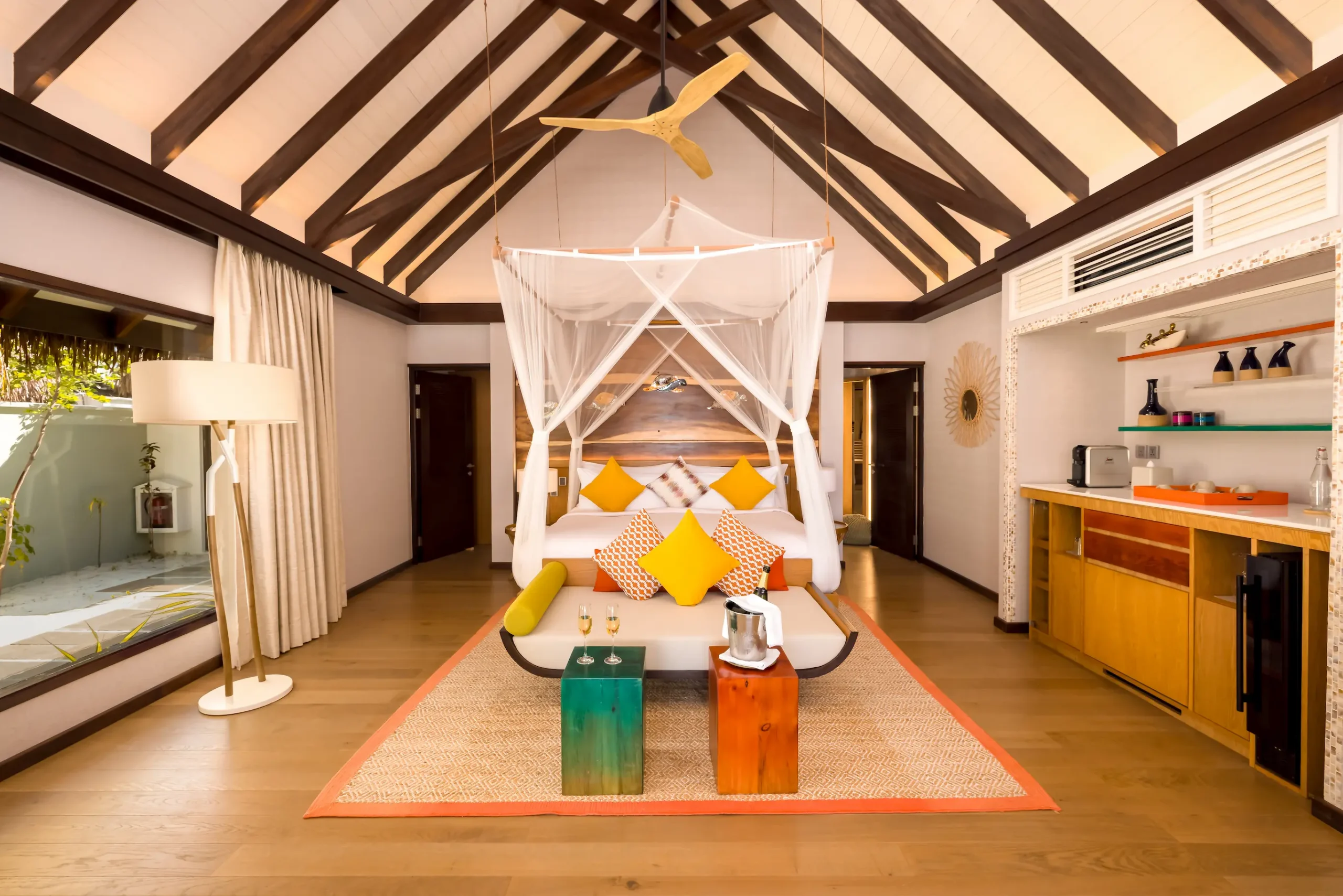Spacious Earth Villa bedroom at OZEN LIFE MAADHOO featuring contemporary décor, high sloping ceilings and direct access to outdoor living spaces.