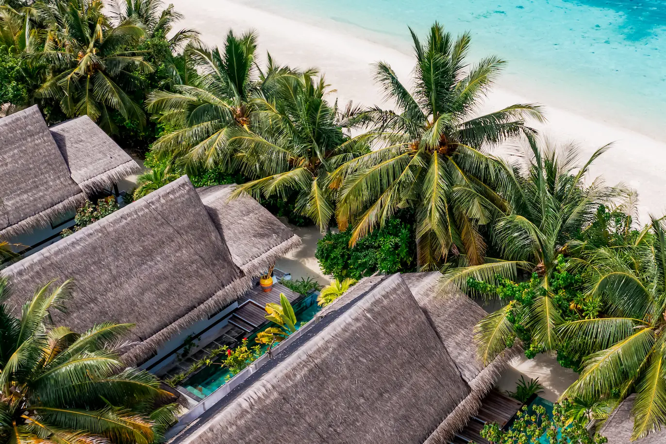 Aerial view of an Earth Villa with Pool at OZEN LIFE MAADHOO, showcasing the beachfront location, private infinity pool, outdoor living space and surrounding island landscape