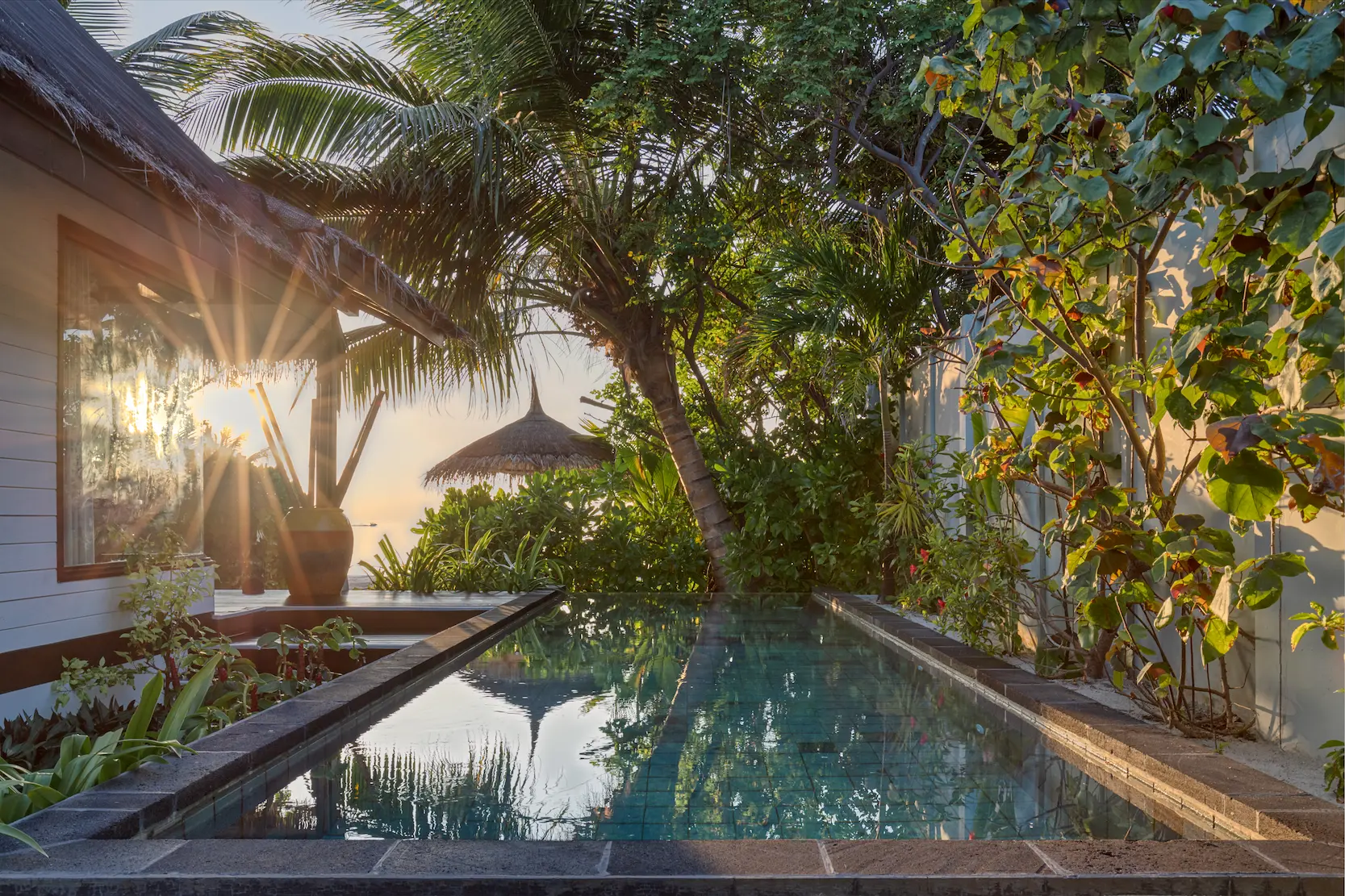 Private pool area at an Earth Villa with Pool at OZEN LIFE MAADHOO at sunset, featuring beachfront surroundings, outdoor relaxation space and views towards the lagoon