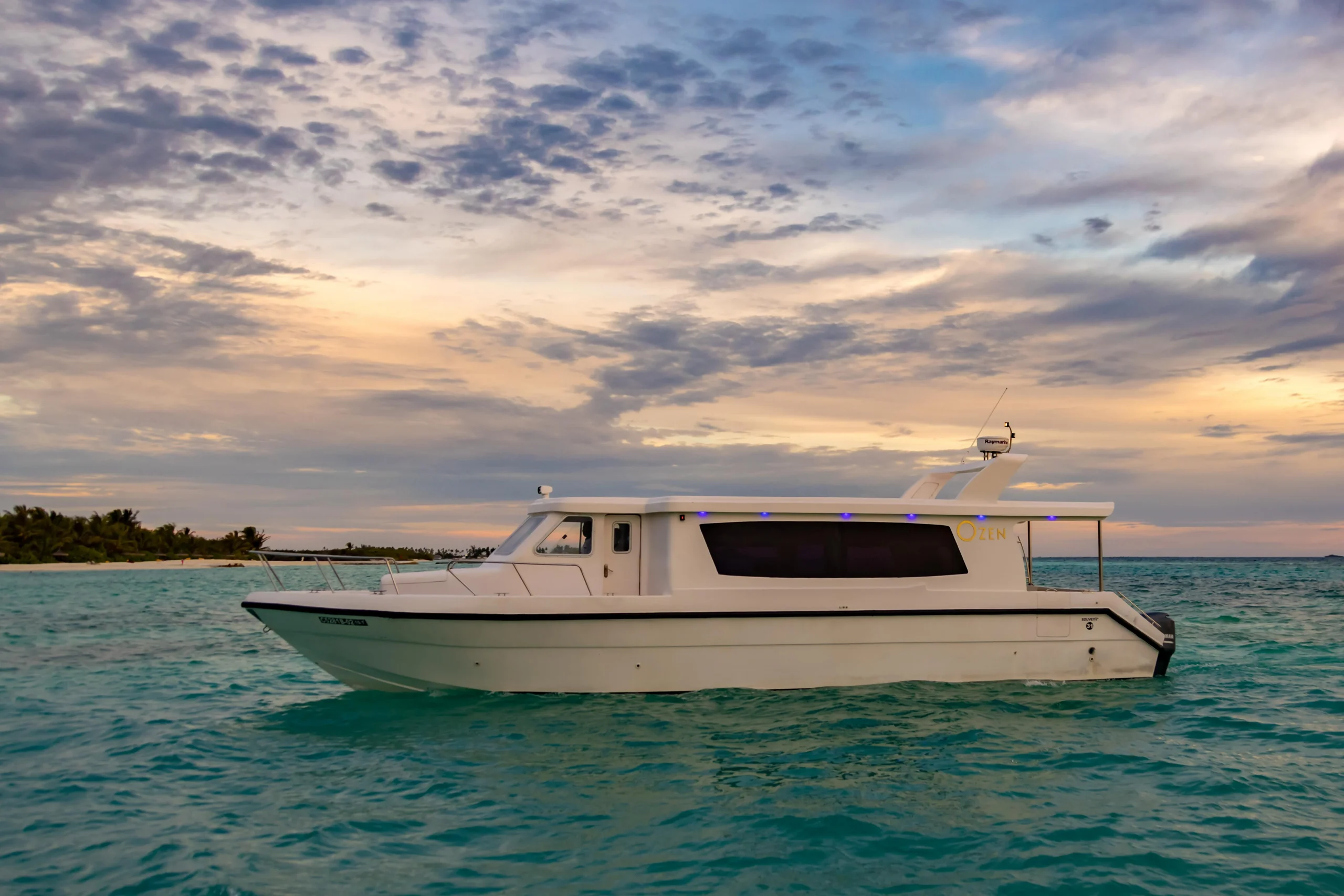 Luxury speedboat transfer arriving at OZEN LIFE MAADHOO, transporting guests across South Malé Atoll with views of the Indian Ocean and surrounding islands.