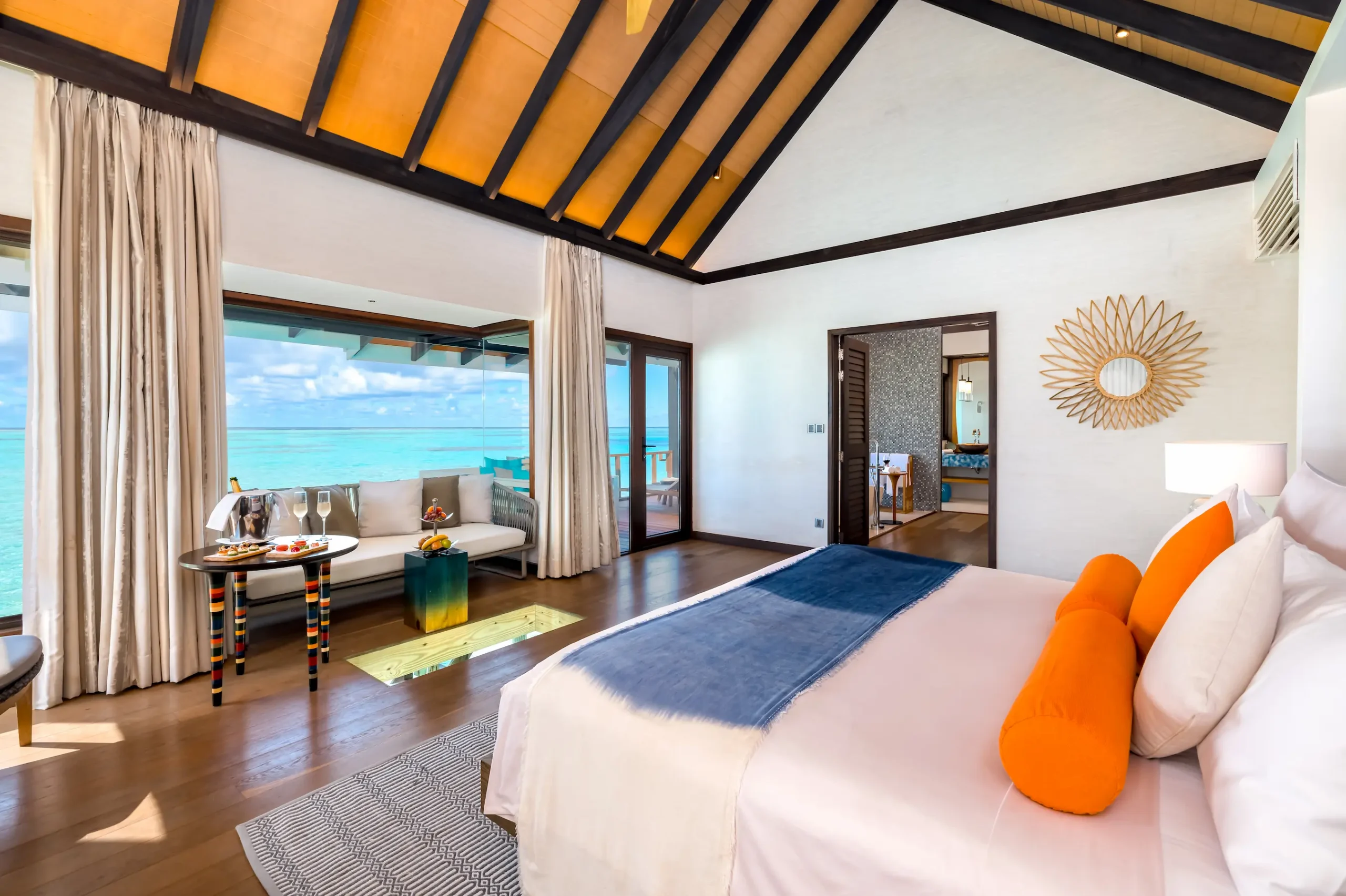 Bedroom in a Wind Villa at OZEN LIFE MAADHOO featuring contemporary interiors and uninterrupted views across the lagoon from the overwater setting