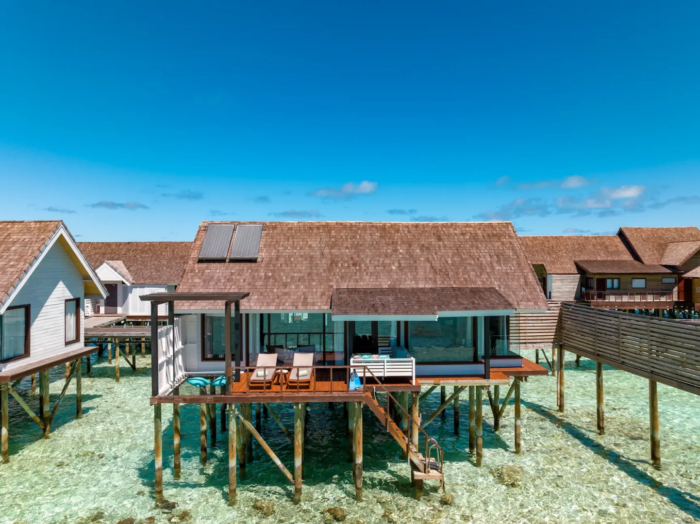 Exterior view of a Wind Villa at OZEN LIFE MAADHOO, positioned above the lagoon with a private sun deck and direct access to the water