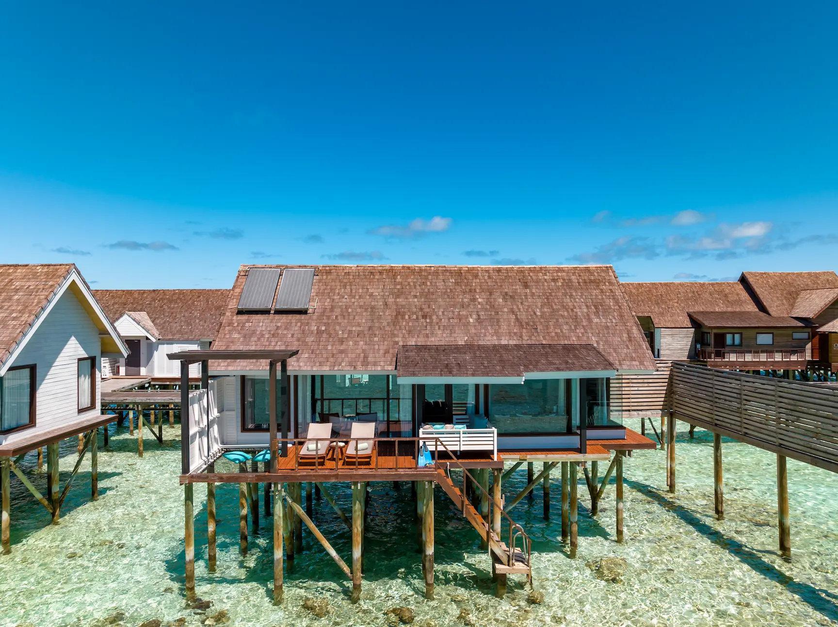 Exterior view of a Wind Villa at OZEN LIFE MAADHOO, positioned above the lagoon with a private sun deck and direct access to the water