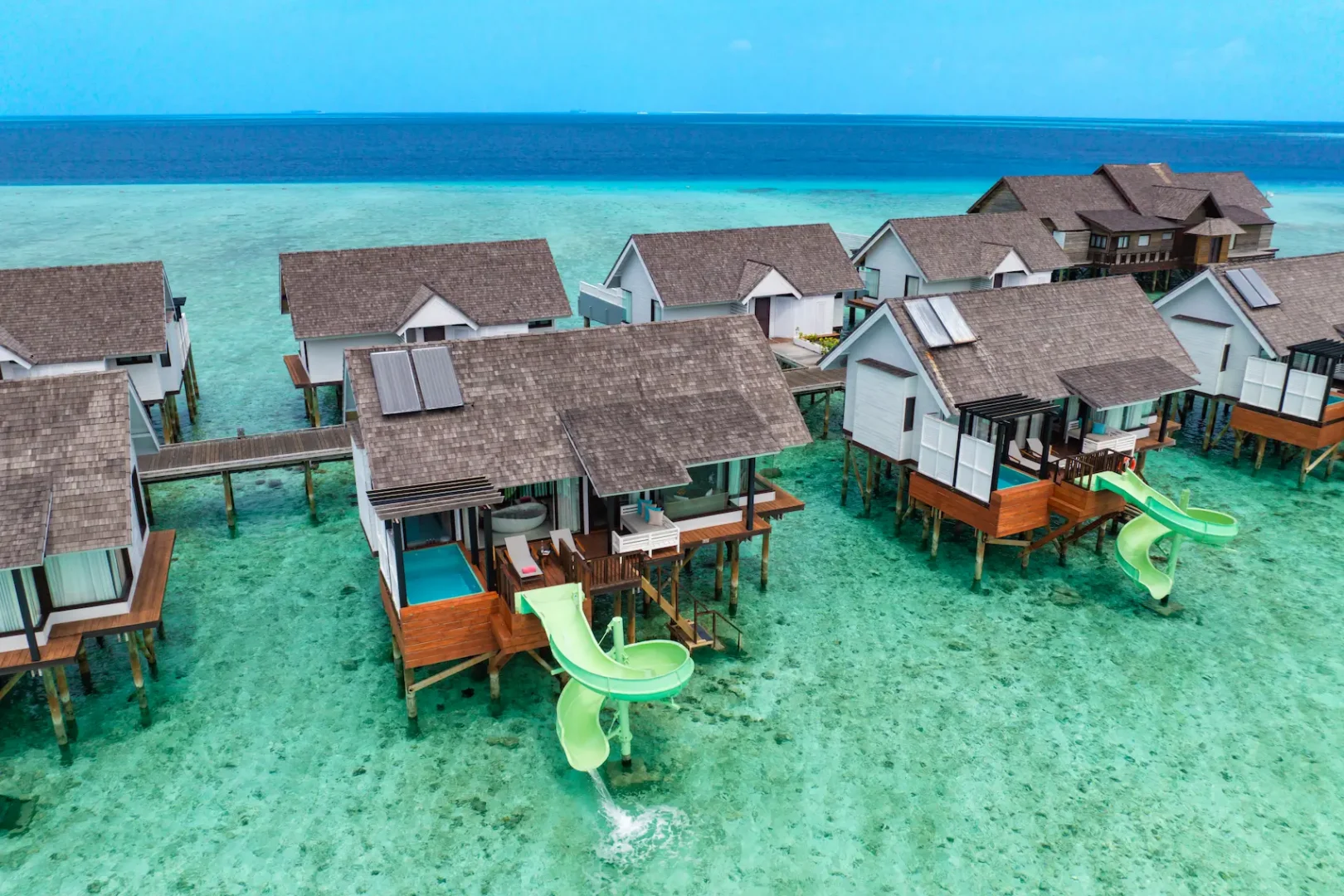 Aerial view of a Wind Villa with Jacuzzi & Slide at OZEN LIFE MAADHOO, showcasing the overwater setting, private outdoor Jacuzzi, waterslide and direct lagoon access.