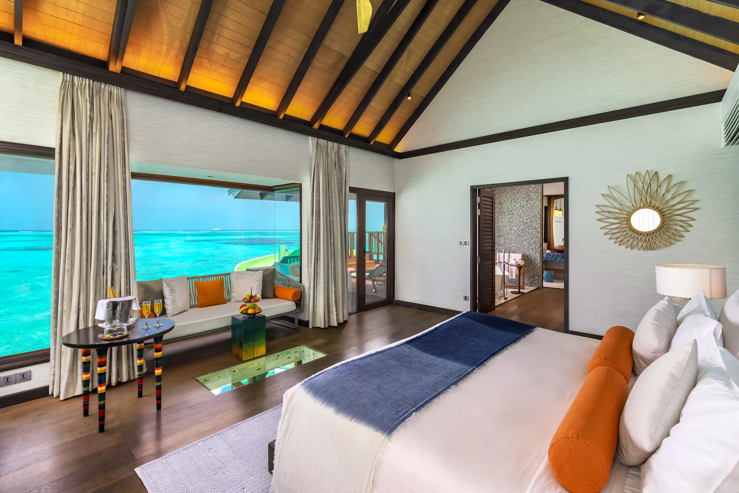 Contemporary bedroom in a Wind Villa with Jacuzzi & Slide at OZEN LIFE MAADHOO, featuring an overwater setting, elegant furnishings and views across the lagoon.
