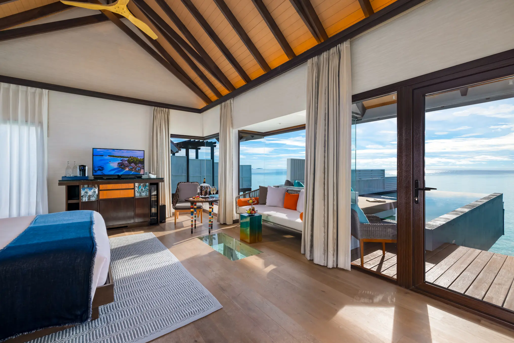 Contemporary bedroom interior in a Wind Villa with Pool at OZEN LIFE MAADHOO, featuring elegant furnishings, an overwater setting and views across the lagoon