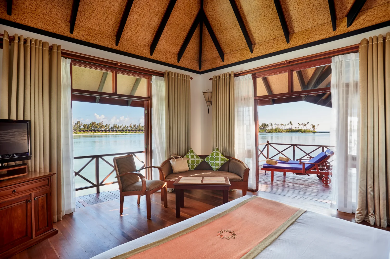 bedroom in a water villa at sun siyam olhuveli maldives with views across the lagoon