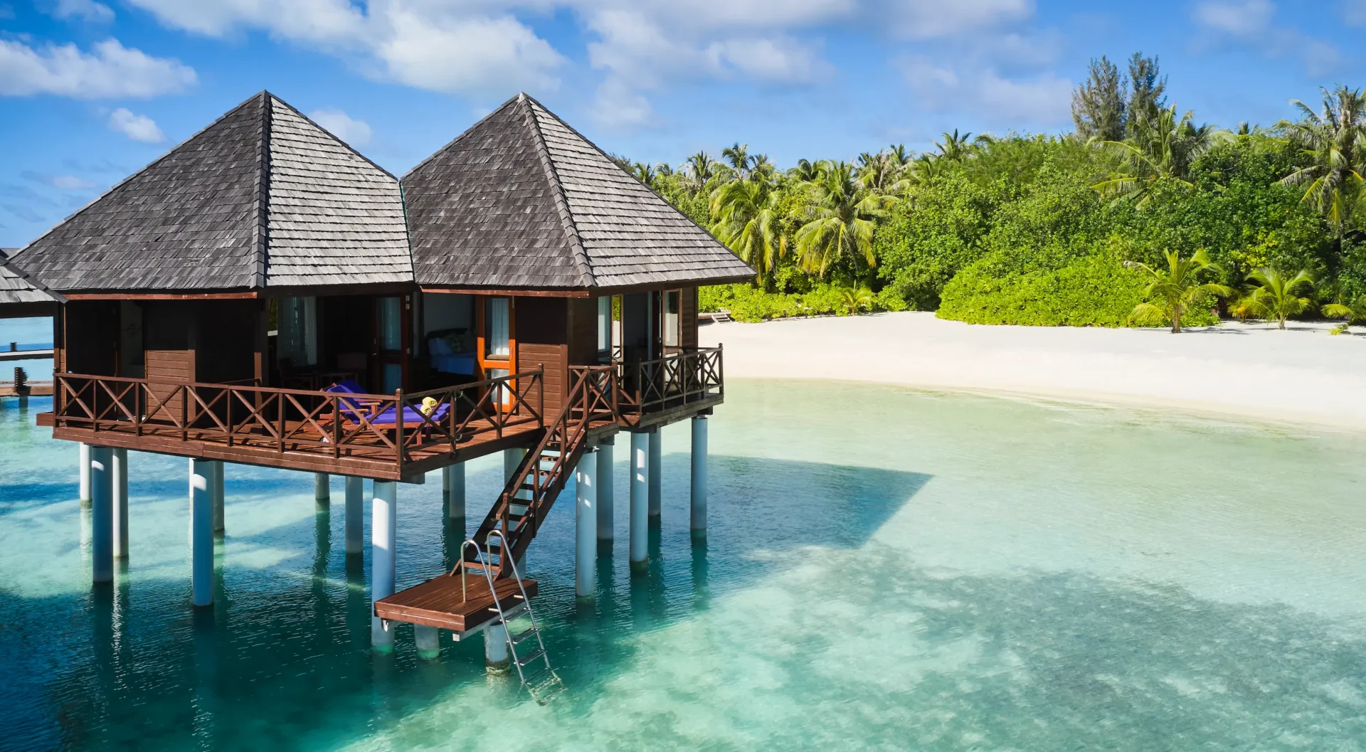 exterior view of a water villa at sun siyam olhuveli maldives positioned above the lagoon with direct water access