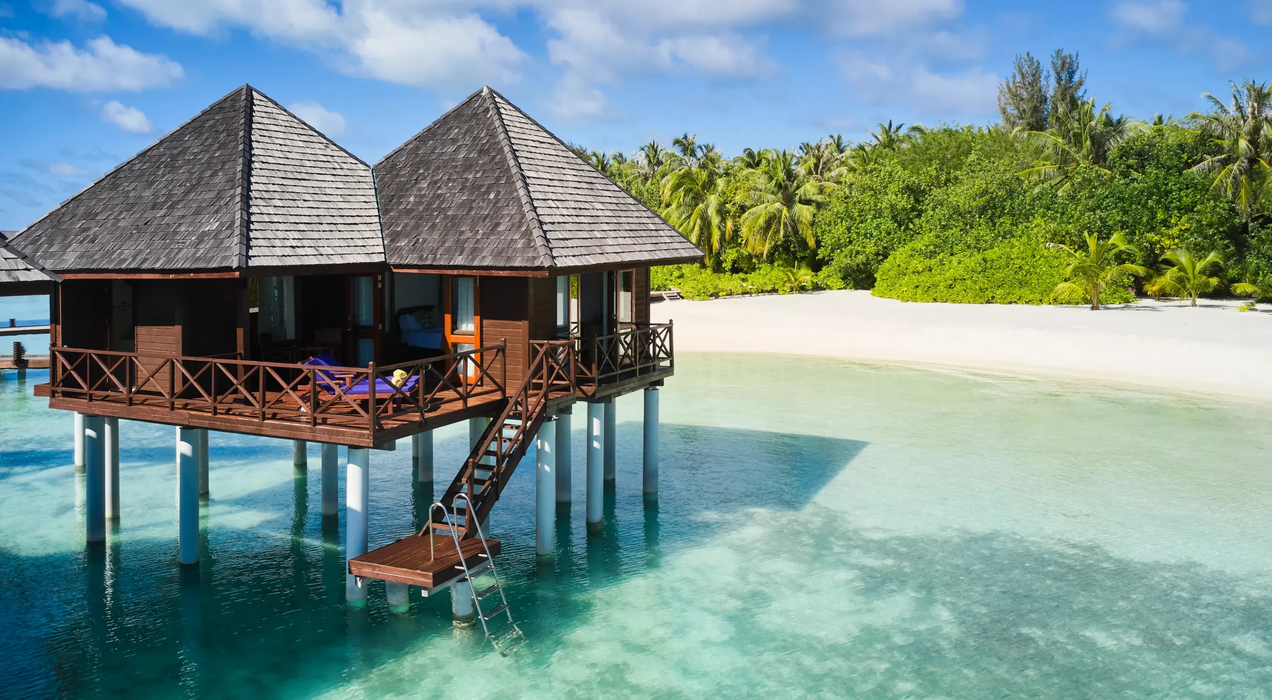 exterior view of a water villa at sun siyam olhuveli maldives positioned above the lagoon with direct water access
