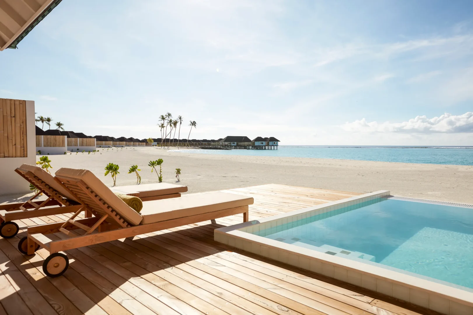 view from a grand beach villa with pool at sun siyam olhuveli maldives overlooking the beach and resort surroundings