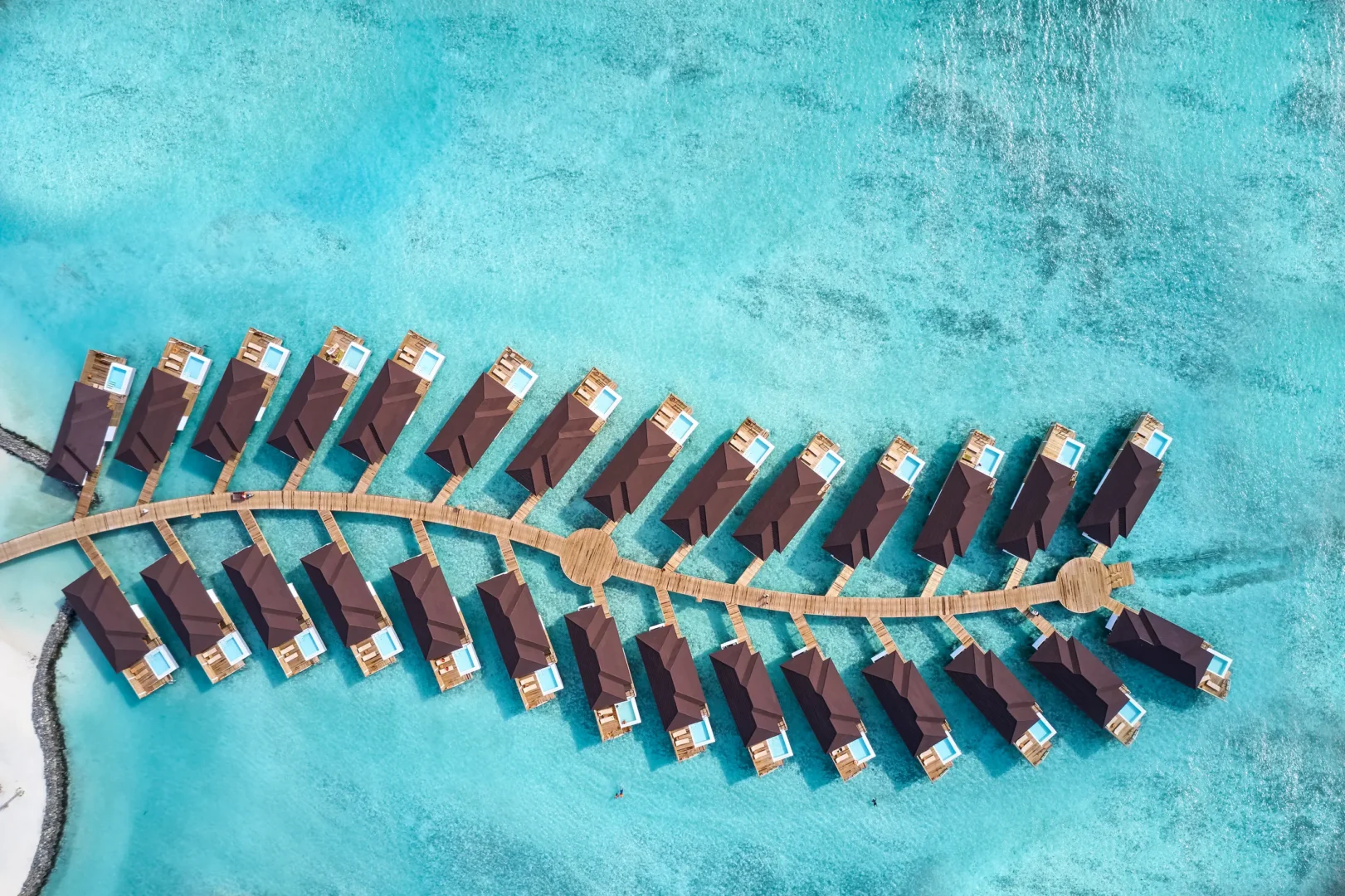 aerial view of grand water villas with pool at sun siyam olhuveli maldives extending across the lagoon