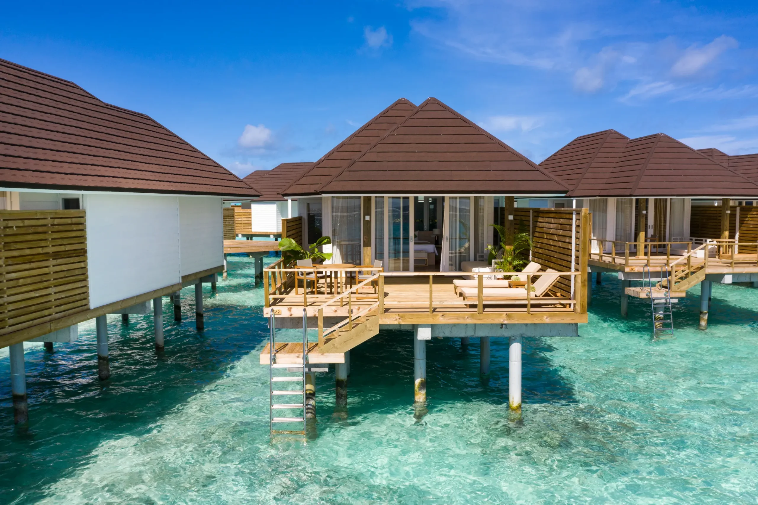 exterior view of a grand water villa at sun siyam olhuveli maldives positioned above the lagoon with direct water access