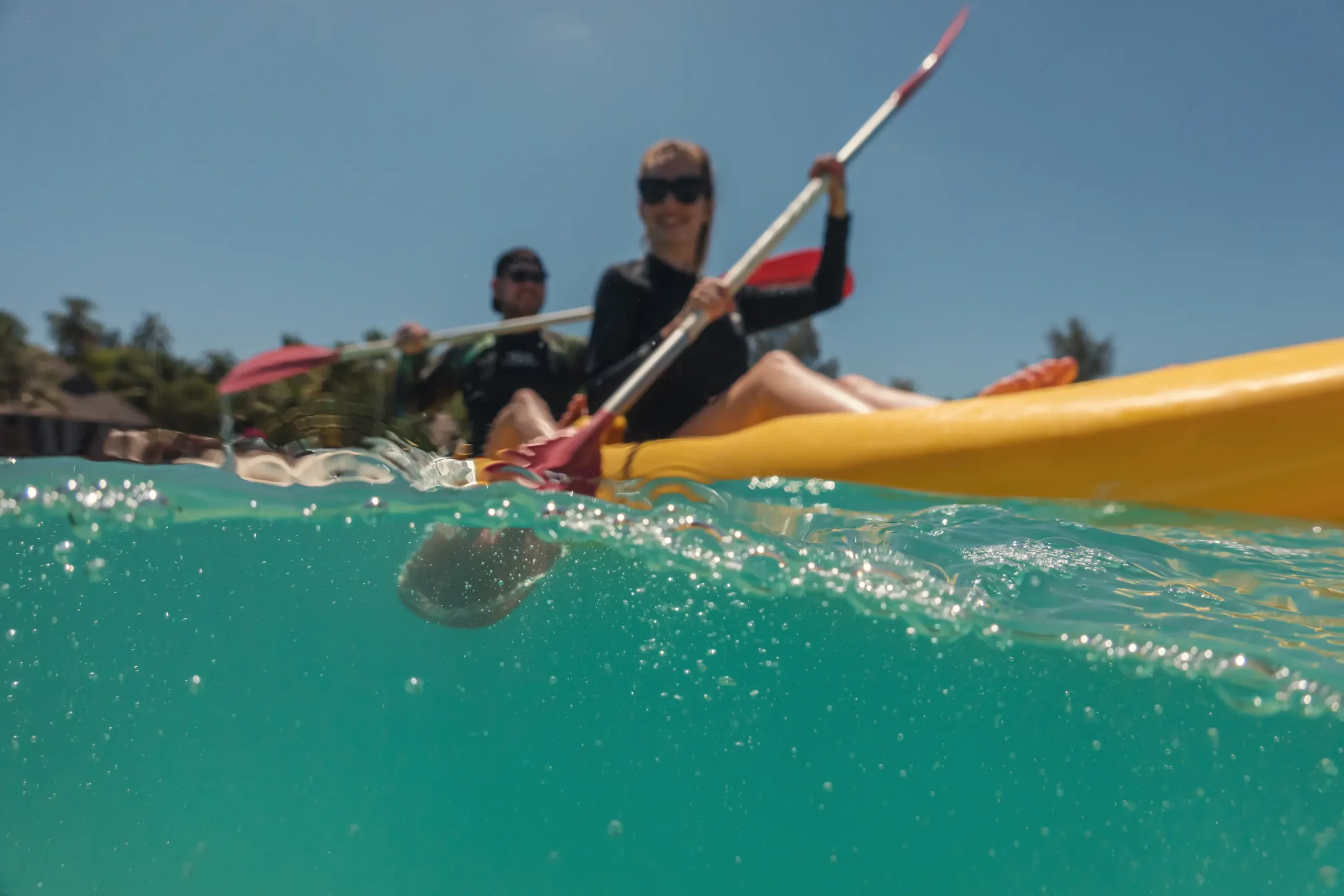 guests enjoying watersports on the lagoon at sun siyam olhuveli maldives including kayaking sailing and jet skiing