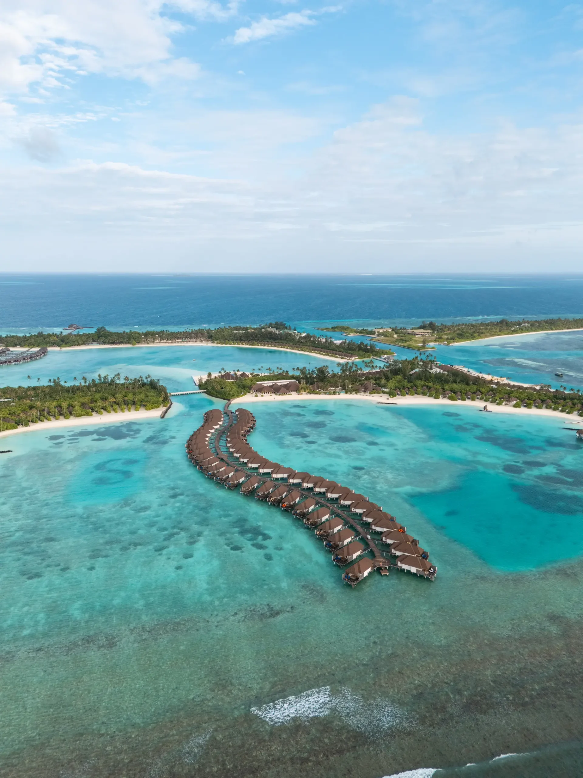 aerial view of overwater villas above the lagoon at sun siyam olhuveli maldives