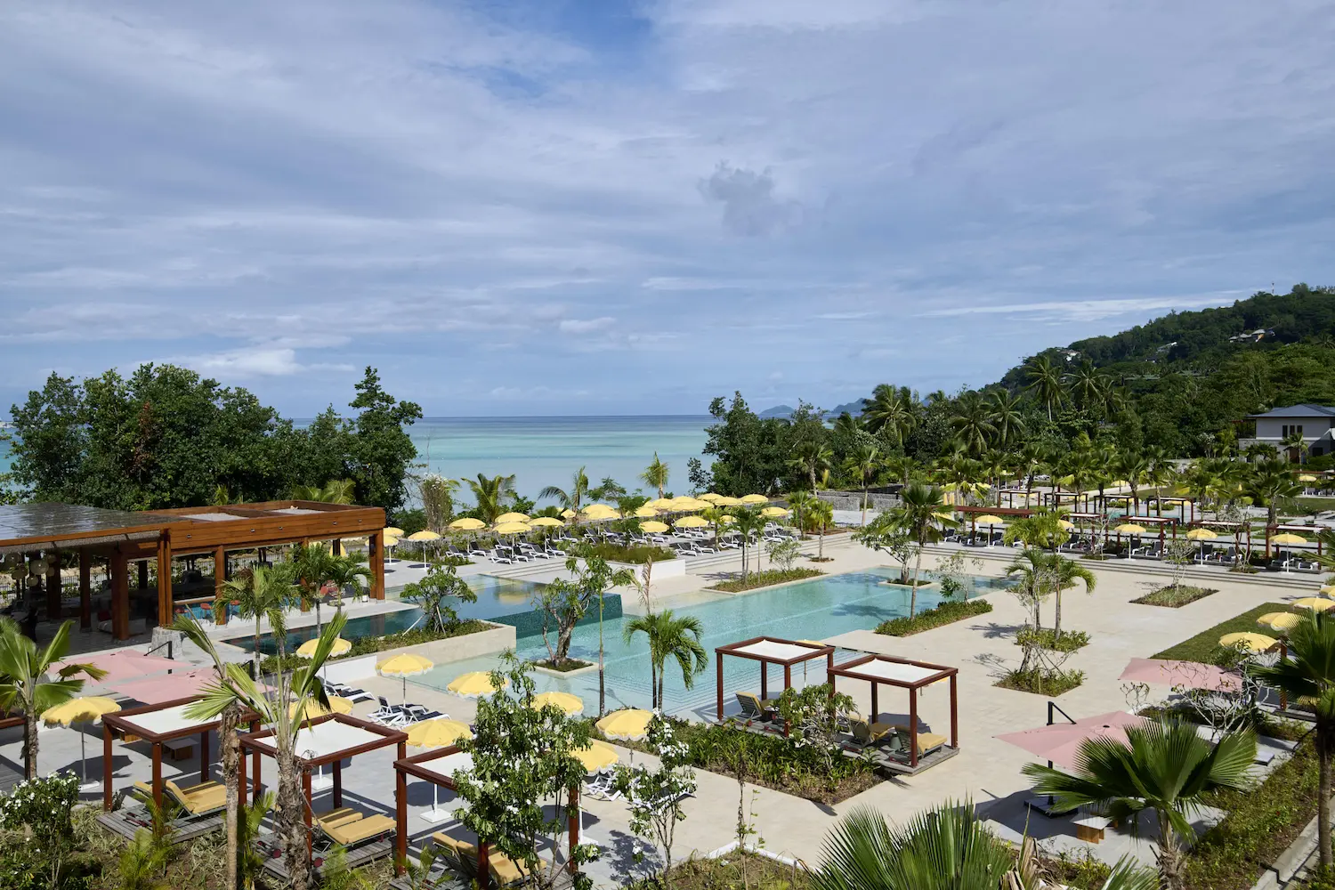 Sega Bar, swimming pool, promenade and beach at Canopy by Hilton Seychelles Resort in Mahé, Seychelles, showcasing the resort's beachfront setting and leisure facilities.