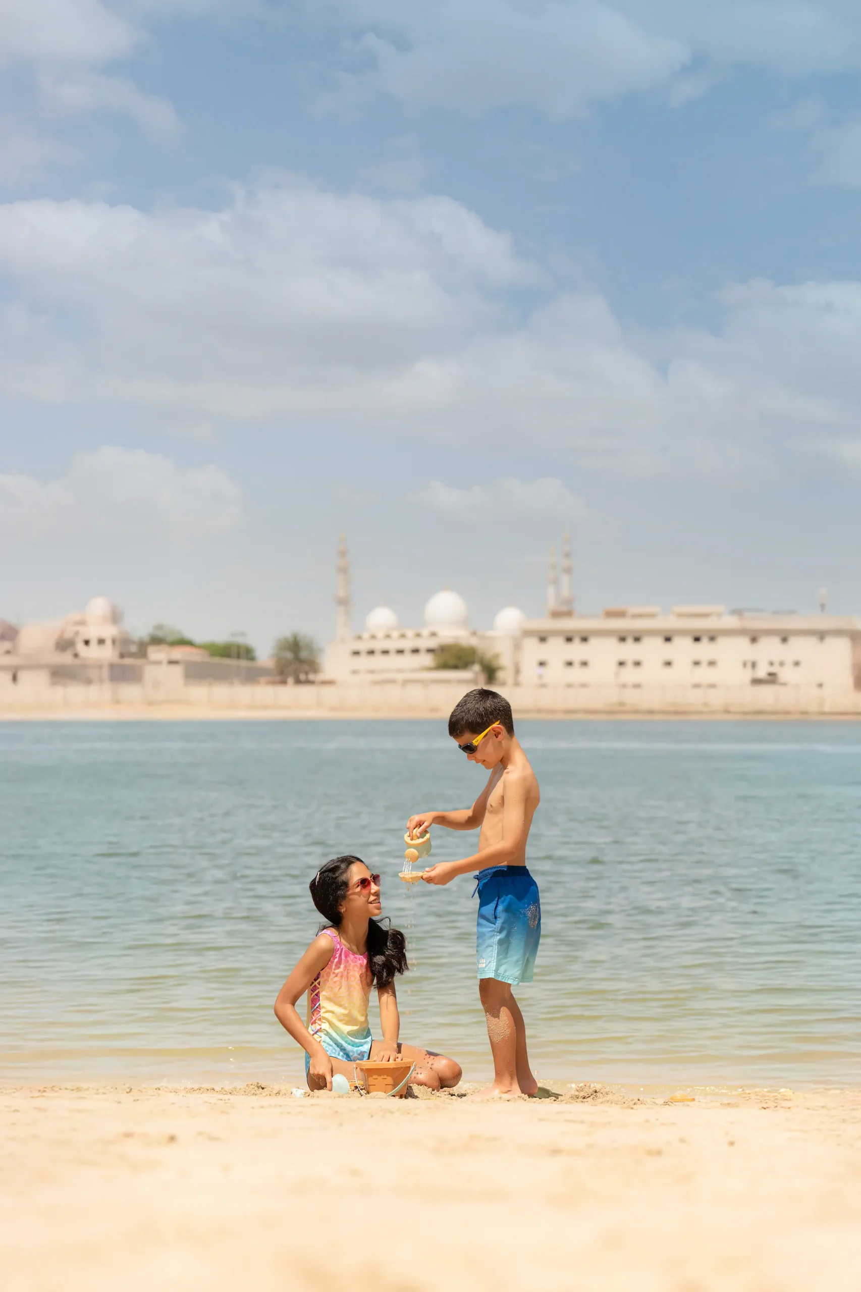 Children enjoying the private beach at Fairmont Bab Al Bahr Abu Dhabi overlooking Abu Dhabi Creek and the Sheikh Zayed Grand Mosque