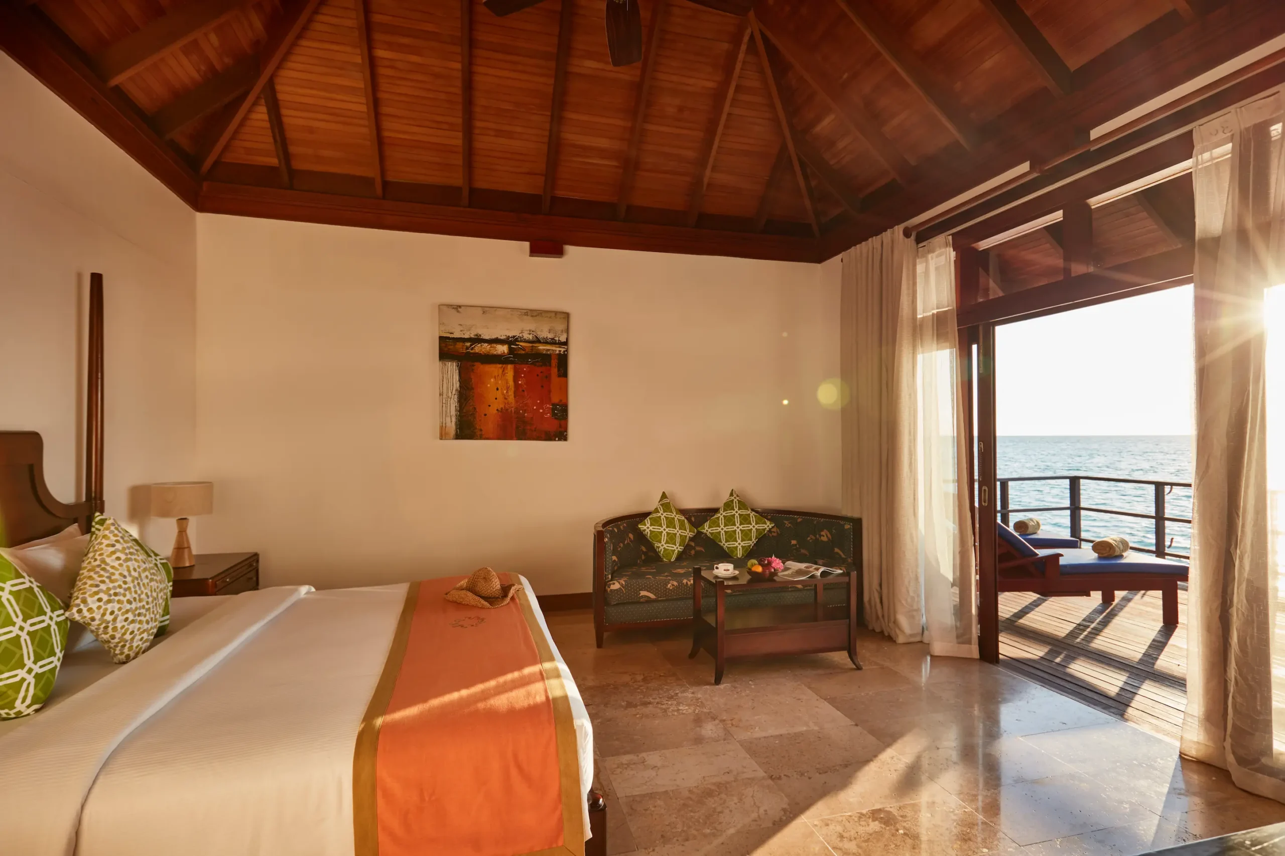 bedroom in a deluxe water villa at sun siyam olhuveli maldives with views across the lagoon