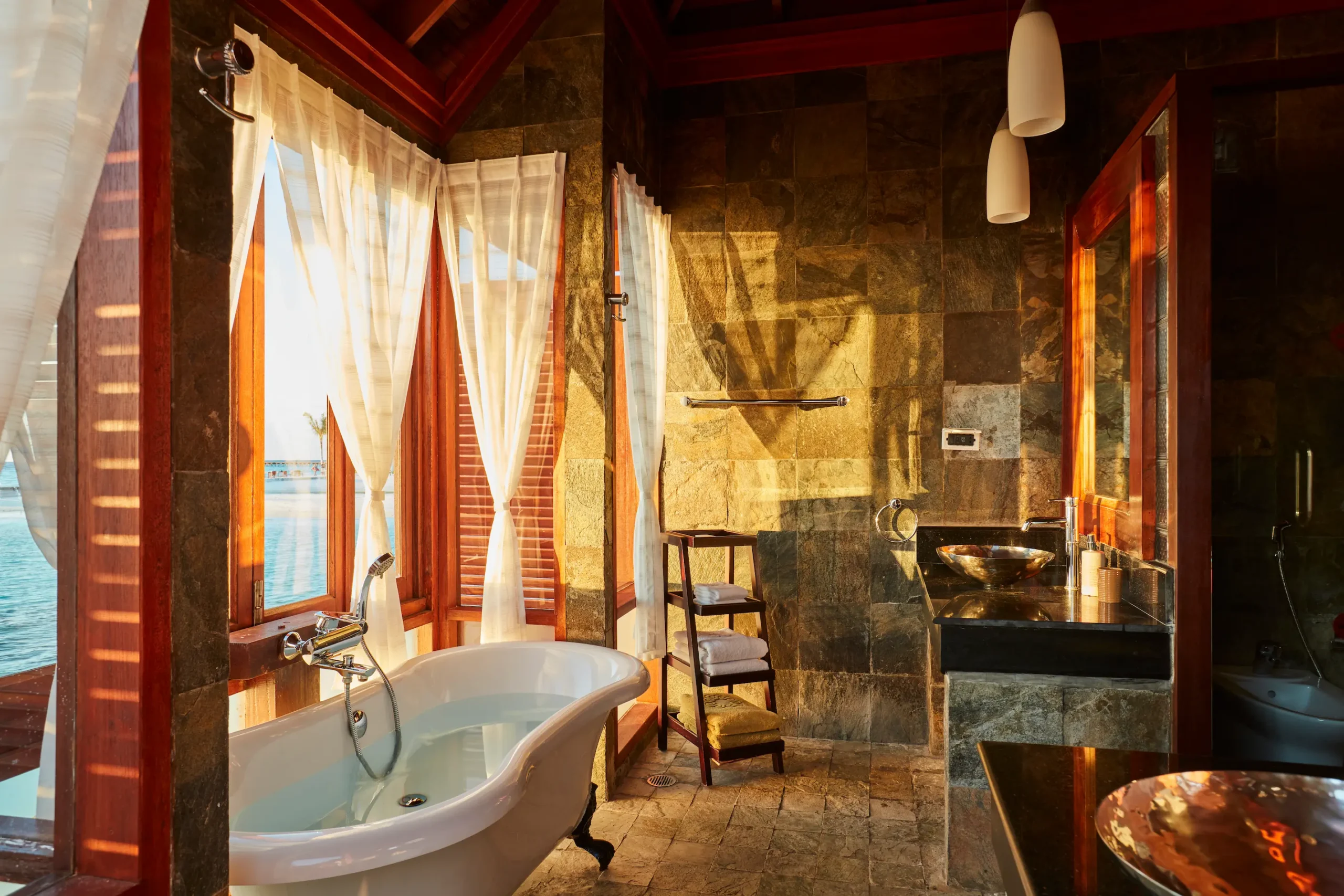 bathroom in a deluxe water villa at sun siyam olhuveli maldives featuring modern amenities and an overwater accommodation setting
