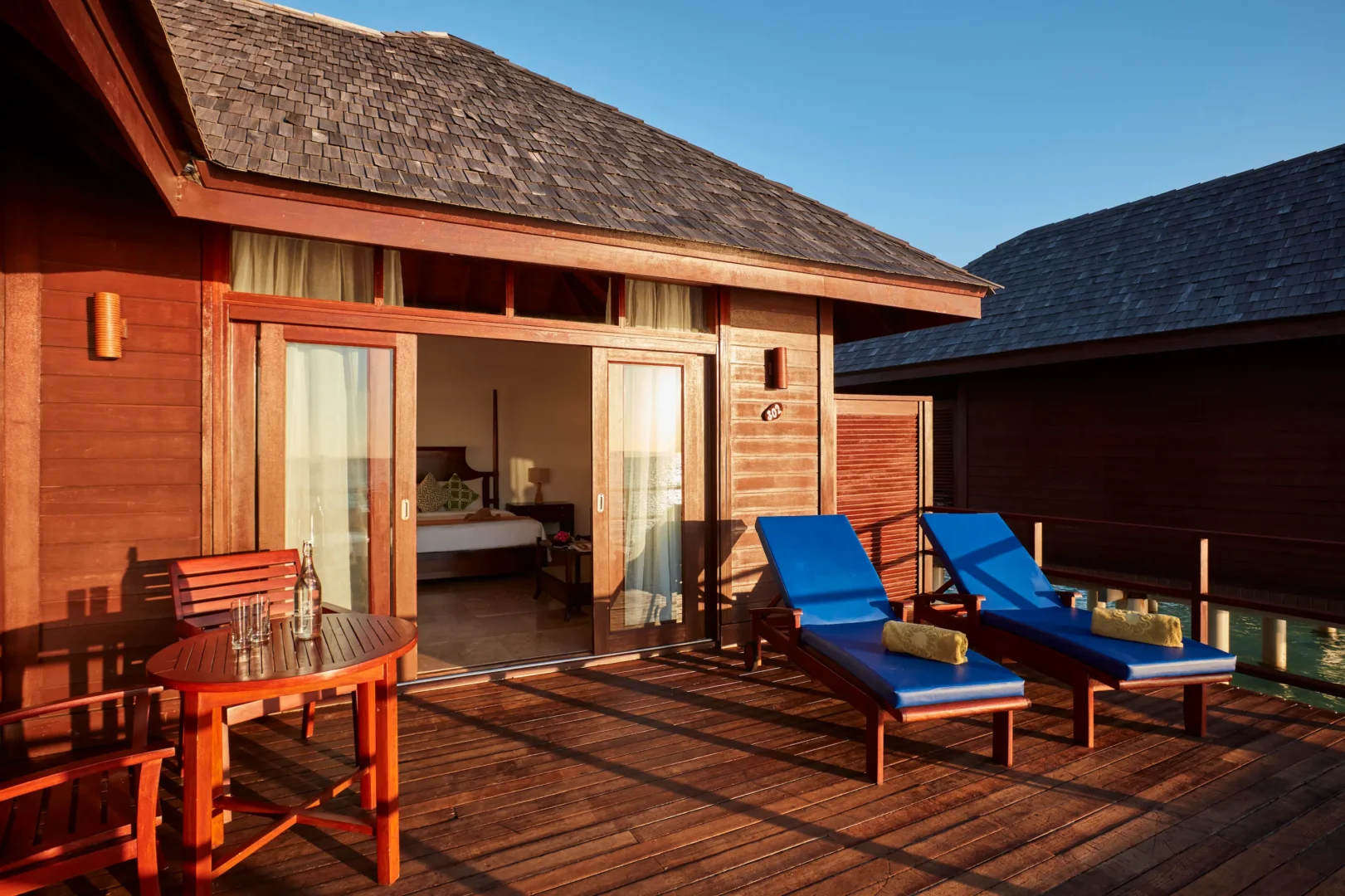 private deck of a deluxe water villa at sun siyam olhuveli maldives with direct access to the lagoon