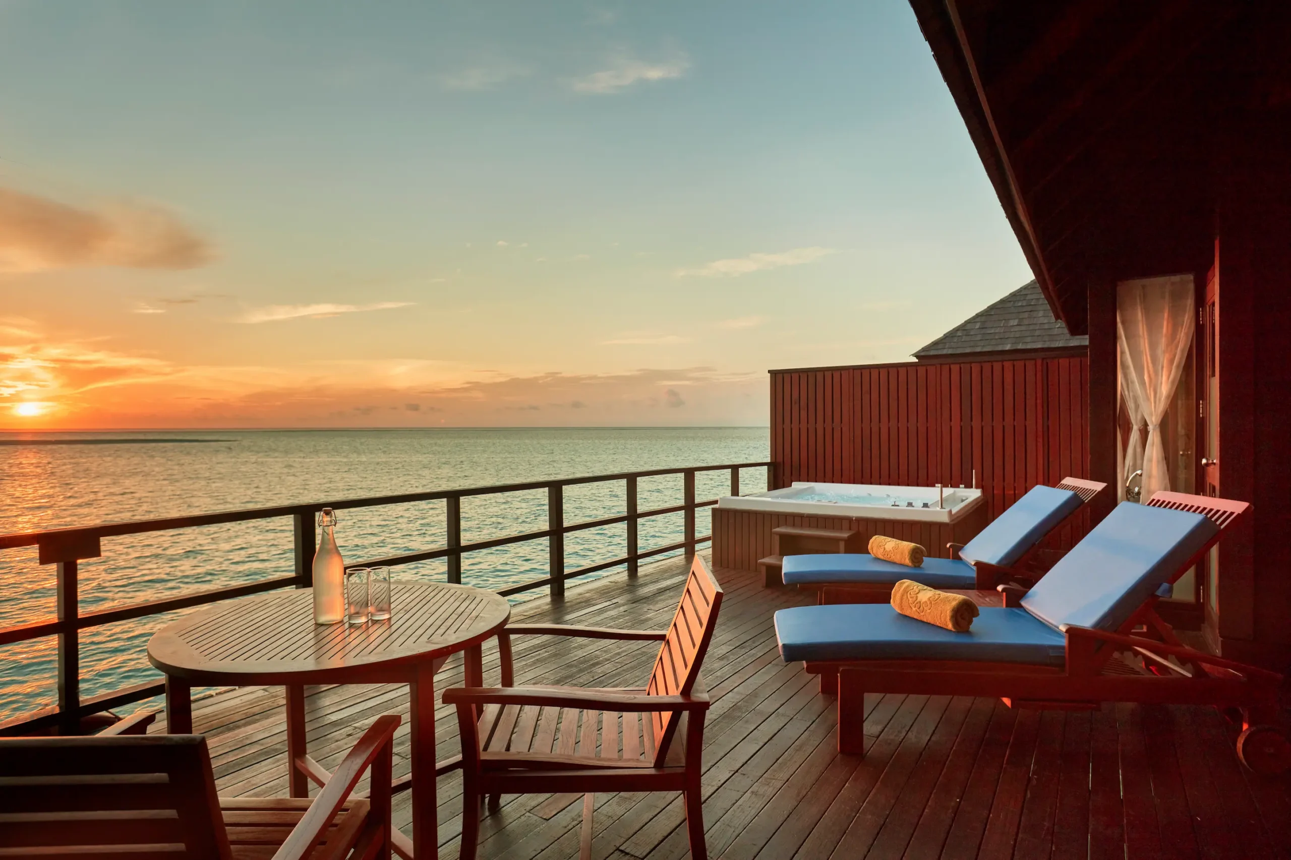 terrace of a prestige jacuzzi water villa at sun siyam olhuveli maldives with outdoor seating above the lagoon