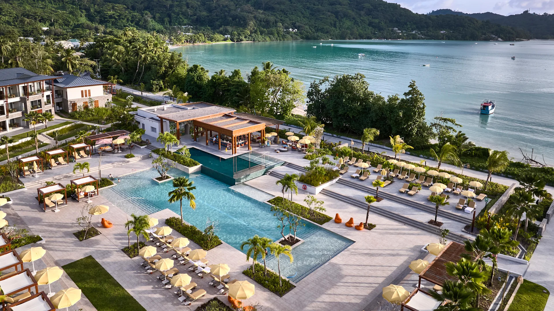 Swimming pool at Canopy by Hilton Seychelles Resort in Mahé, Seychelles, surrounded by sun loungers and offering views across the resort grounds.