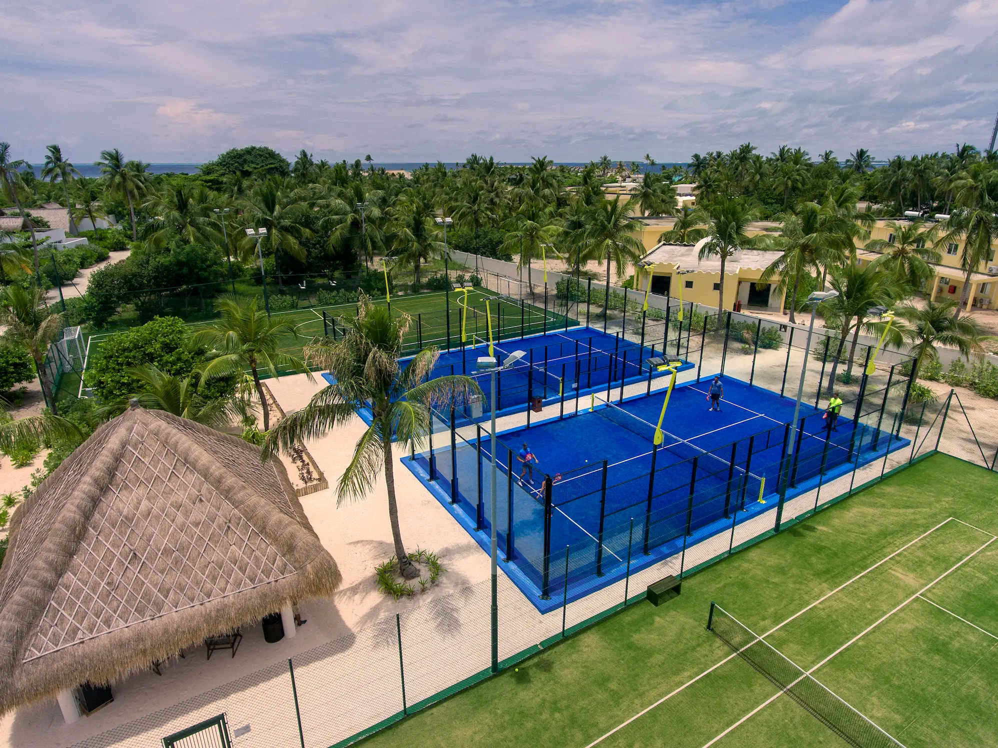 sports centre at emerald maldives resort & spa in the maldives featuring a fitness centre, tennis courts and padel courts