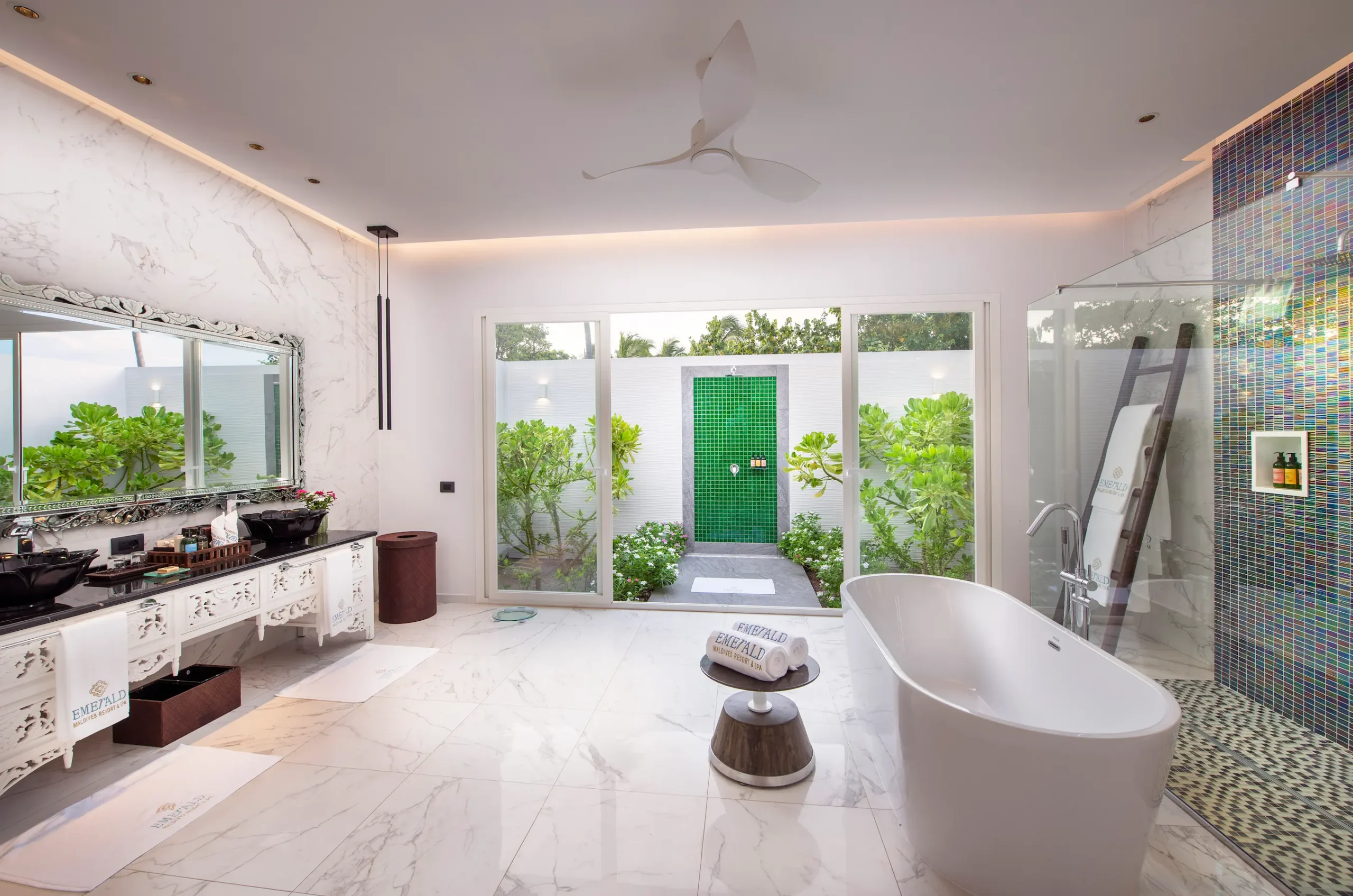 bathroom in a jacuzzi beach villa at emerald maldives resort & spa in the maldives featuring a bathtub, walk-in shower and access to a private outdoor jacuzzi